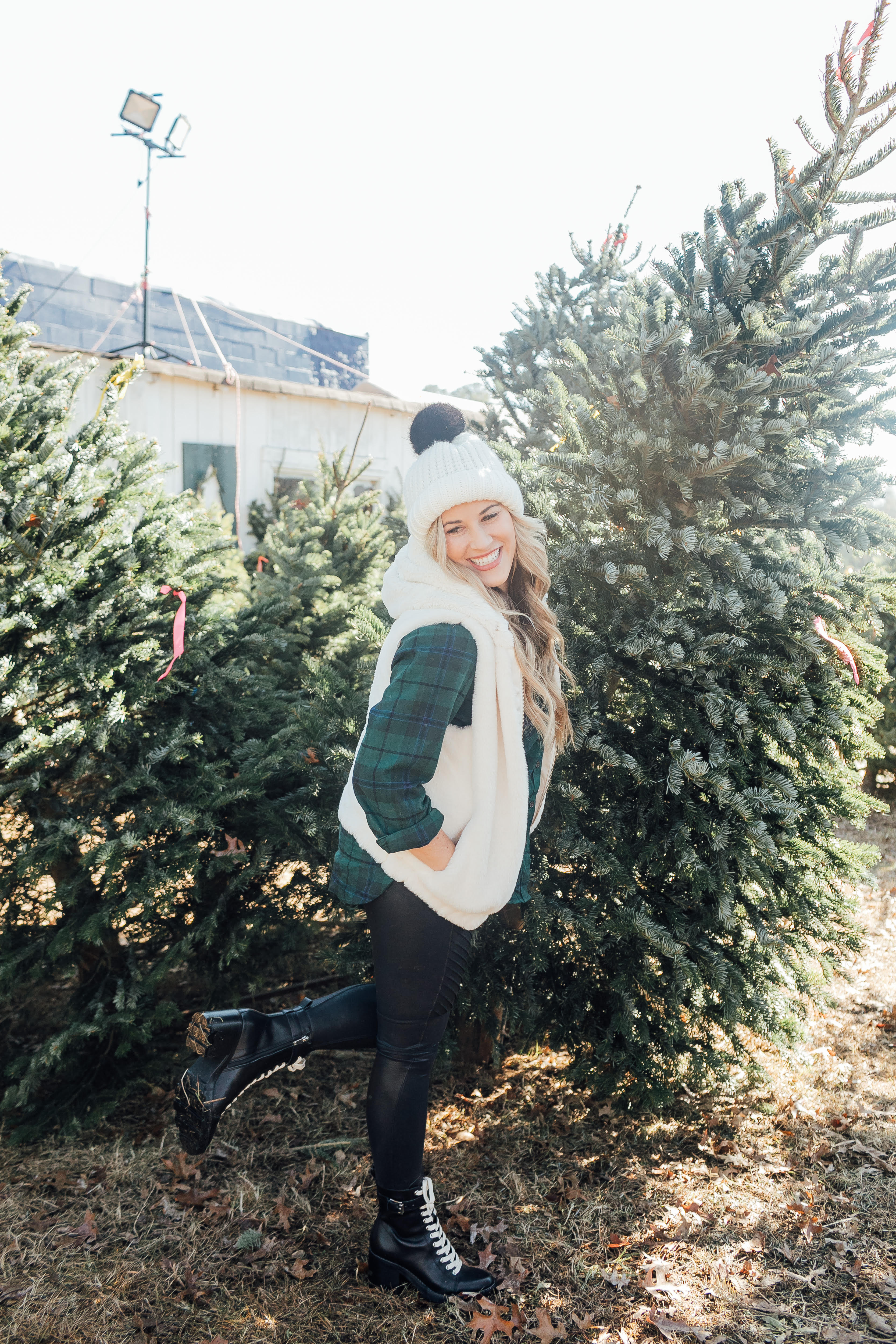 How to style SPANX faux leather leggings featured by top US fashion blog, Walking in Memphis in High Heels: image of a woman wearing SPANX faux leather leggings, Old Navy plaid shirt, faux shearling hooded vest, Marc Fisher ankle boots and ASOS pom pom beanie