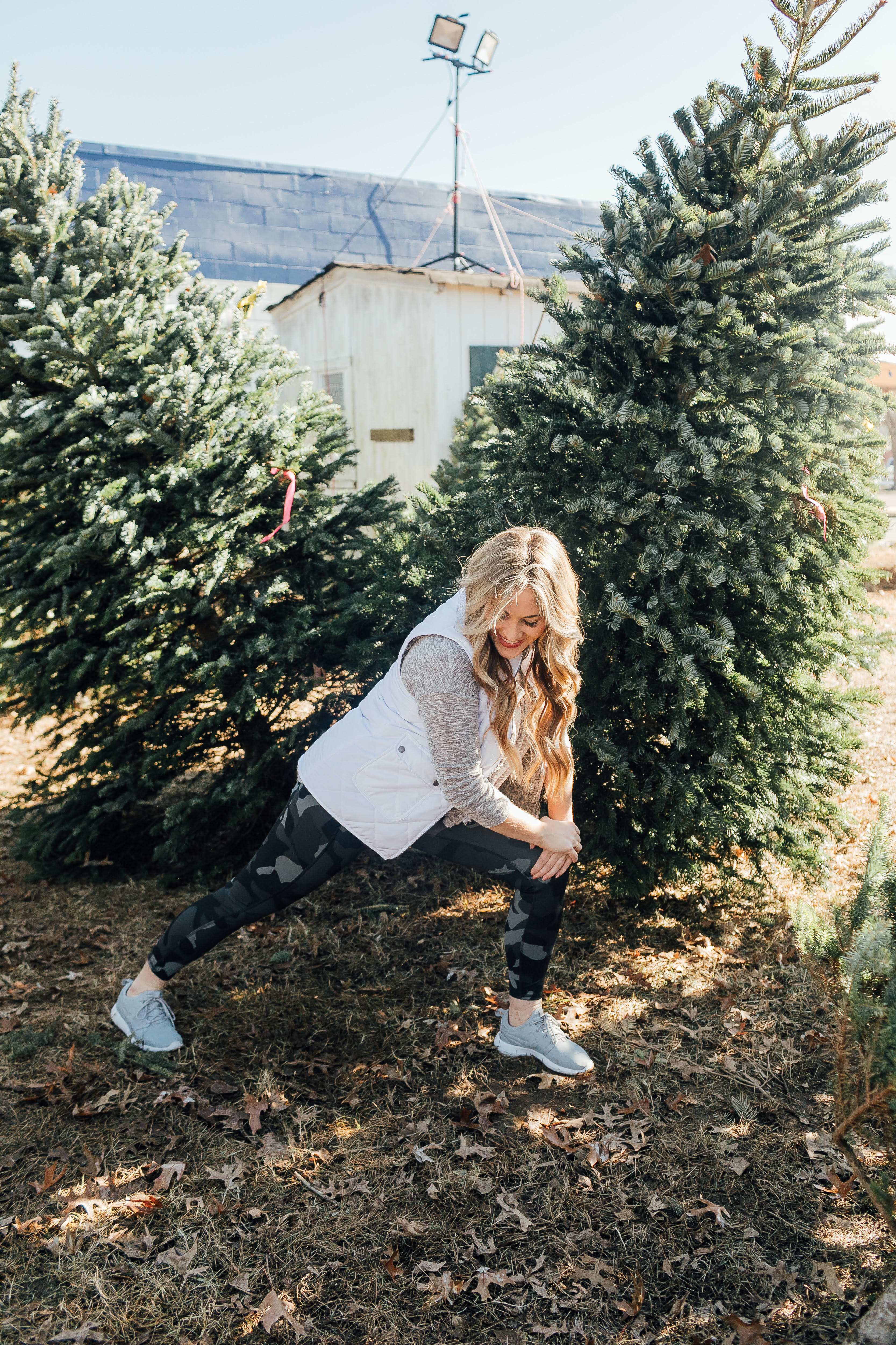 Full Abs Workout featured by top US fitness blog, Walking in Memphis in High Heels, as part of their Holiday Honey Hustle Challenge: image of a woman working out at a Christmas tree farm