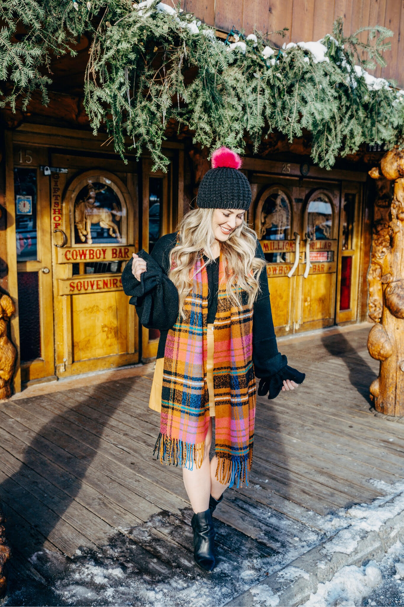 Christmas party look featured by top US fashion blog, Walking in Memphis in High Heels: image of a woman wearing a black Oracle sweater, Free People faux leather mini skirt, hot pink pom pom beanie, ASOS check scarf and Sole Society sock booties