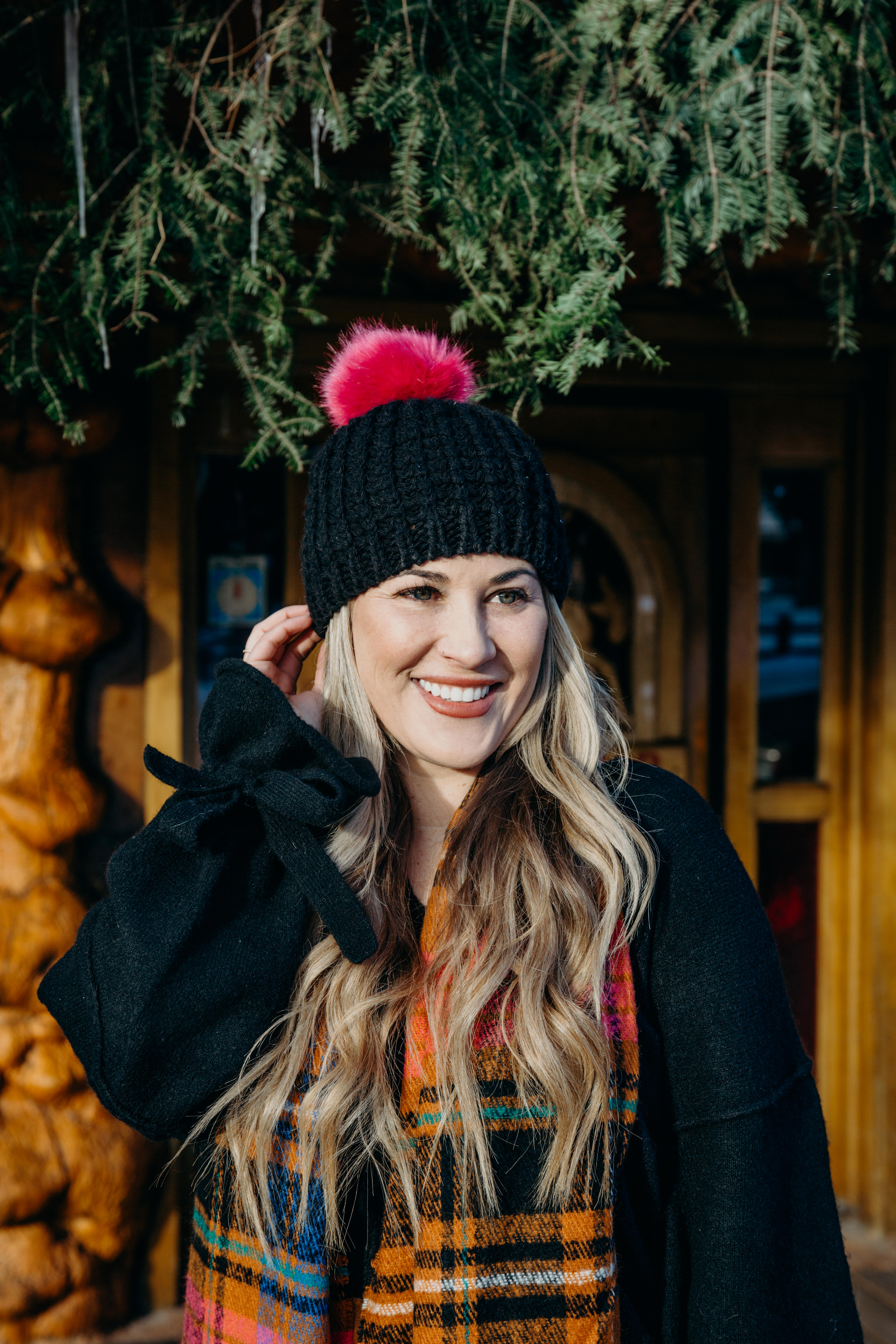 Christmas party look featured by top US fashion blog, Walking in Memphis in High Heels: image of a woman wearing a black Oracle sweater, Free People faux leather mini skirt, hot pink pom pom beanie, ASOS check scarf and Sole Society sock booties