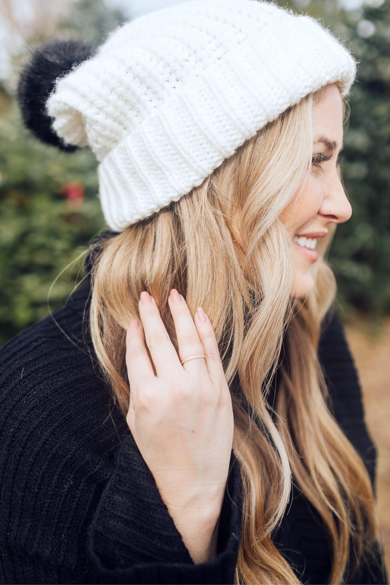 Winter accessories featured by top US fashion blog, Walking in Memphis in High Heels: image of a blonde woman walking in a Christmas tree farm wearing a Free People mini skirt, Melroseand Market sweater, Rebecca Minkoff pompom beanie, Sole Society Sock Bootie