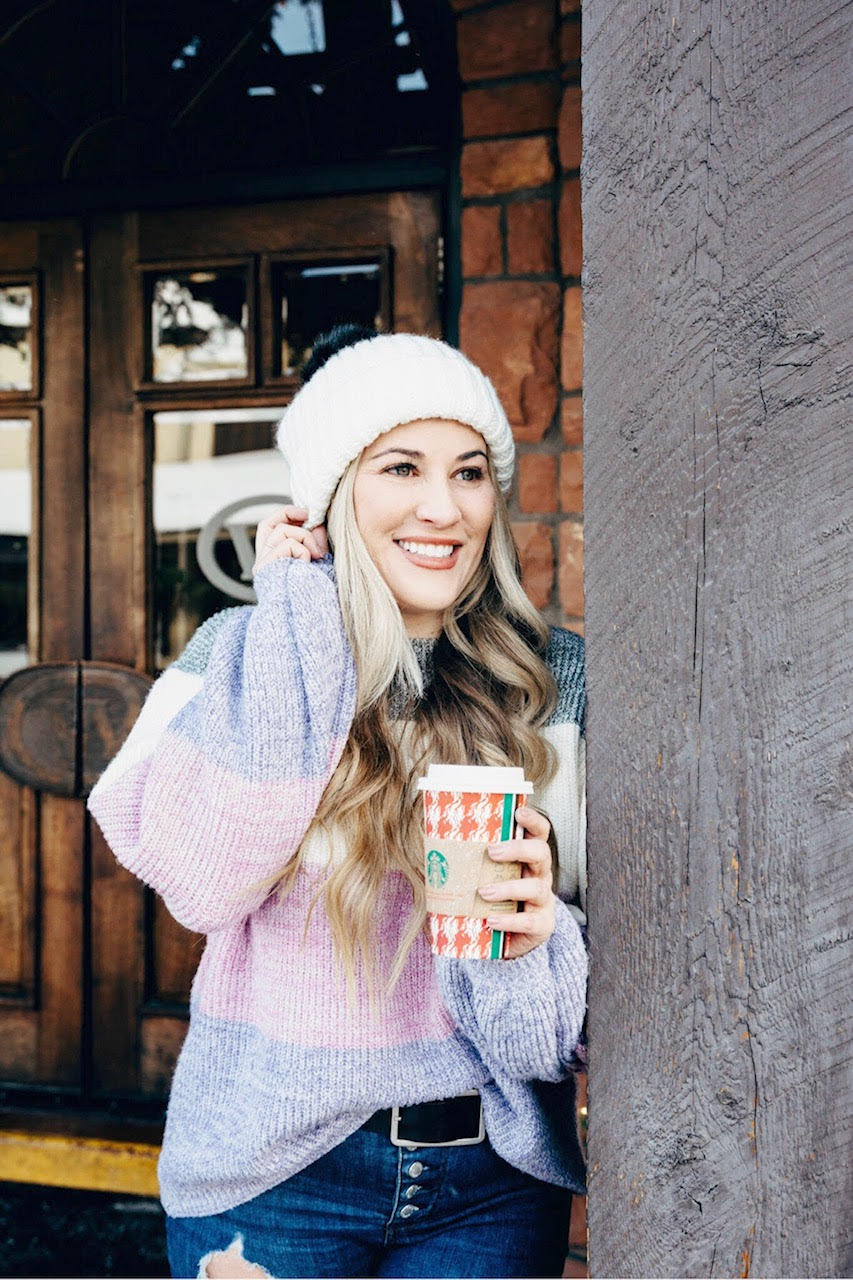 Pink Lily striped sweater styled by top US fashion blog, Walking in Memphis in High Heels: image of a woman wearing a Pink Lily striped sweater, Free People skinny jeans, Double faux fur pom pom beanie and Sole Society sole booties