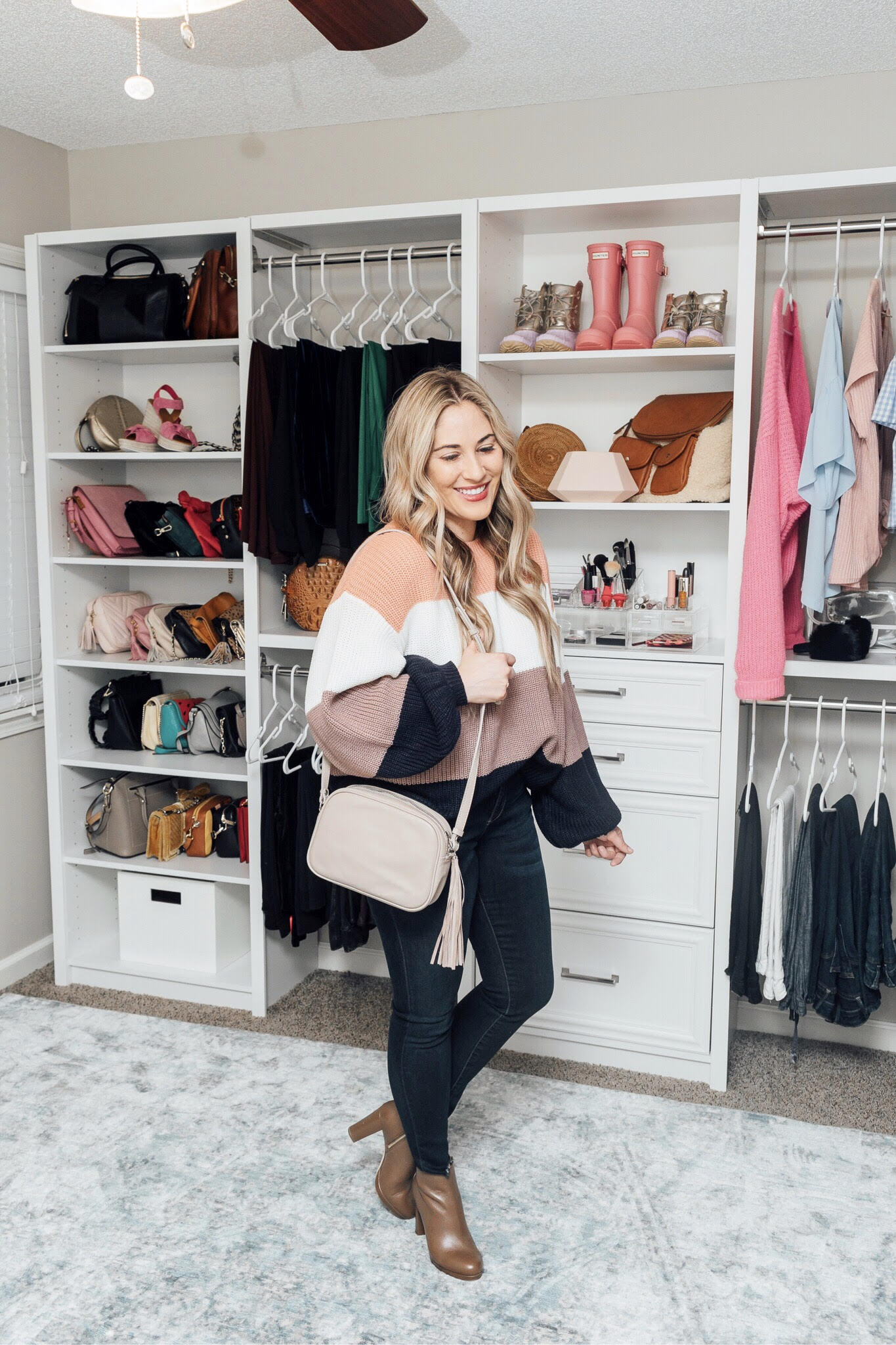 Essentials to pack for your Valentines Getaway: image of a woman wearing a Pink Lily color block sweater, Zappos skinny jeans, and Michael Kors booties