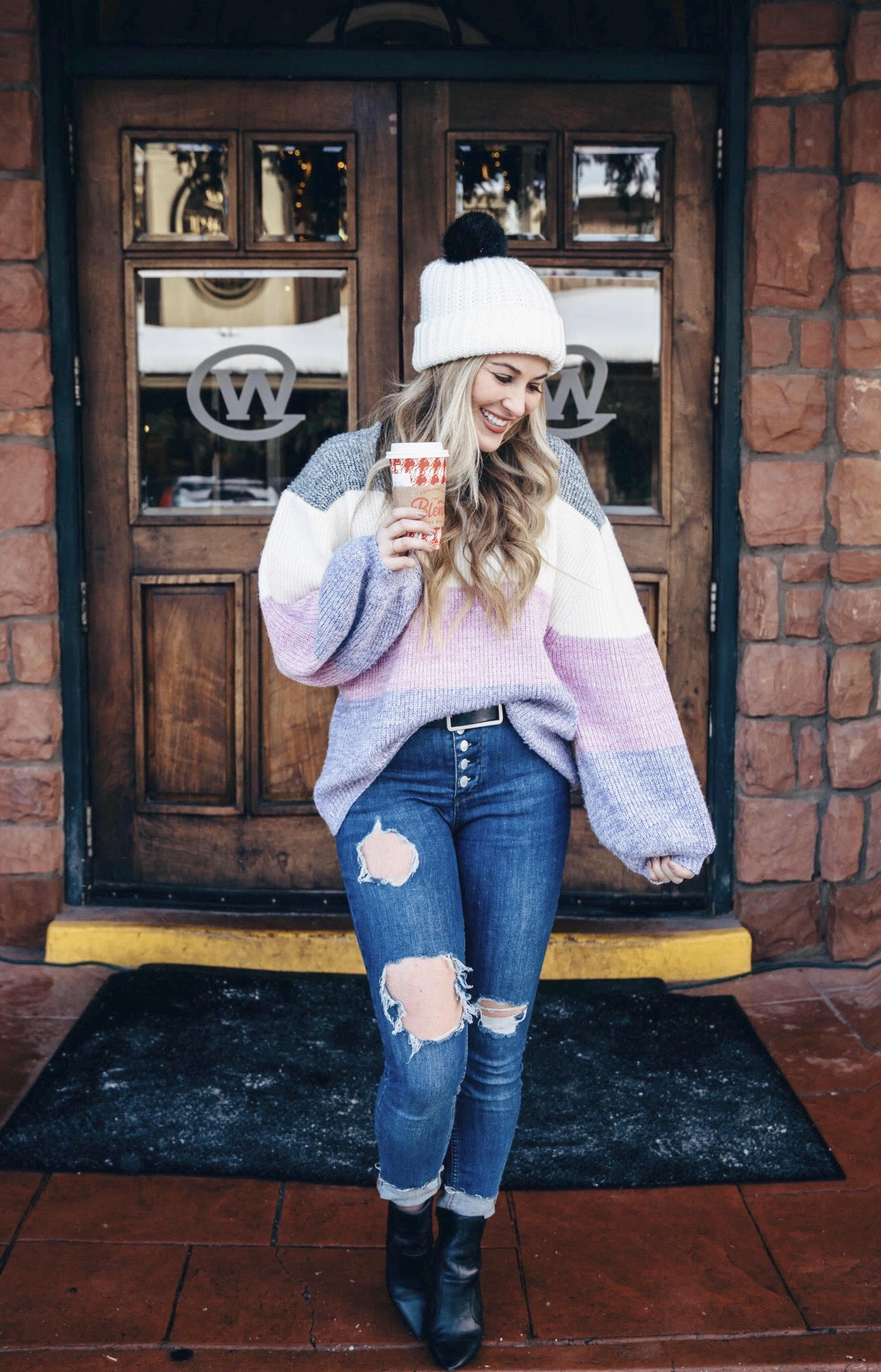Pink Lily striped sweater styled by top US fashion blog, Walking in Memphis in High Heels: image of a woman wearing a Pink Lily striped sweater, Free People skinny jeans, Double faux fur pom pom beanie and Sole Society sole booties