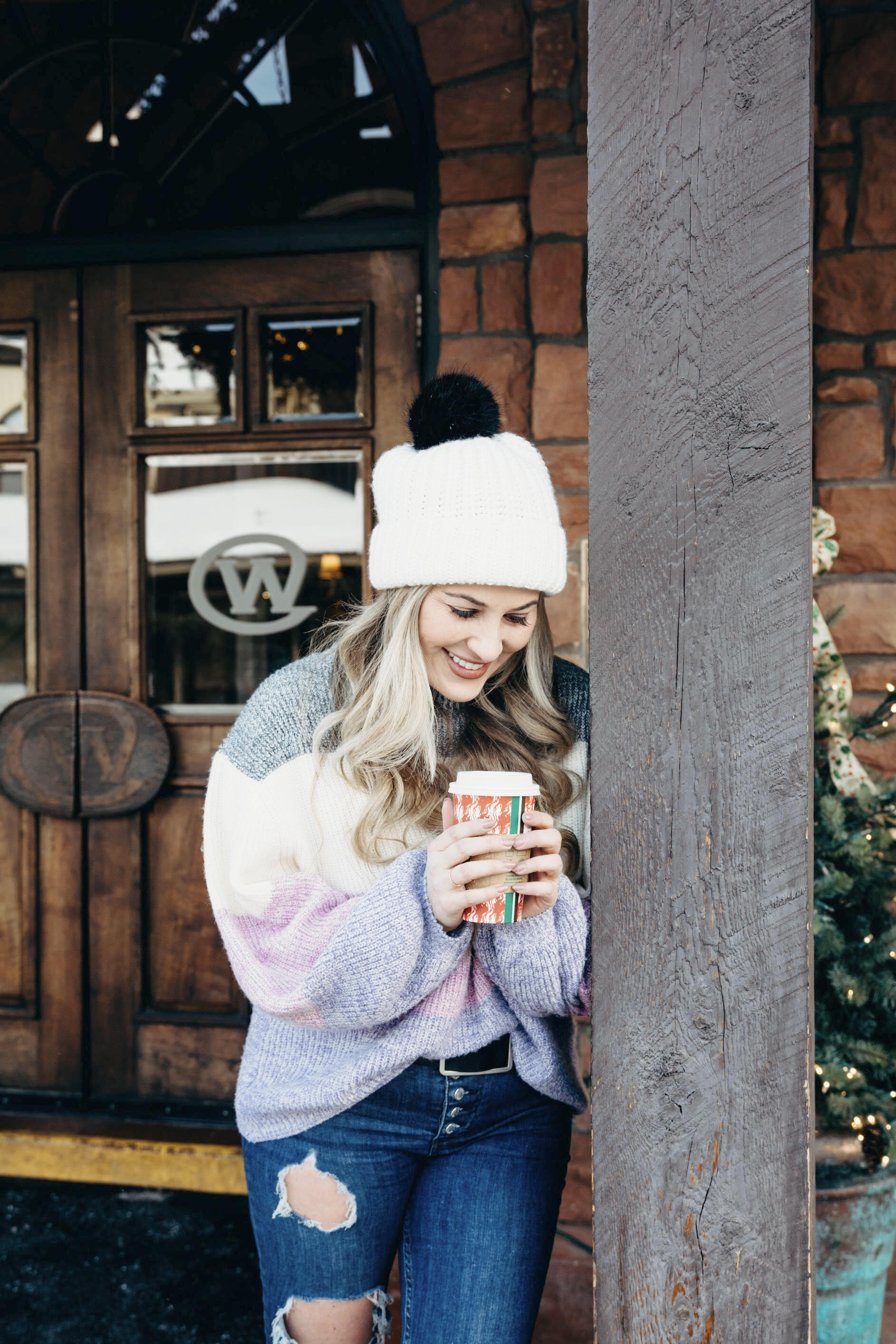 Pink Lily striped sweater styled by top US fashion blog, Walking in Memphis in High Heels: image of a woman wearing a Pink Lily striped sweater, Free People skinny jeans, Double faux fur pom pom beanie and Sole Society sole booties