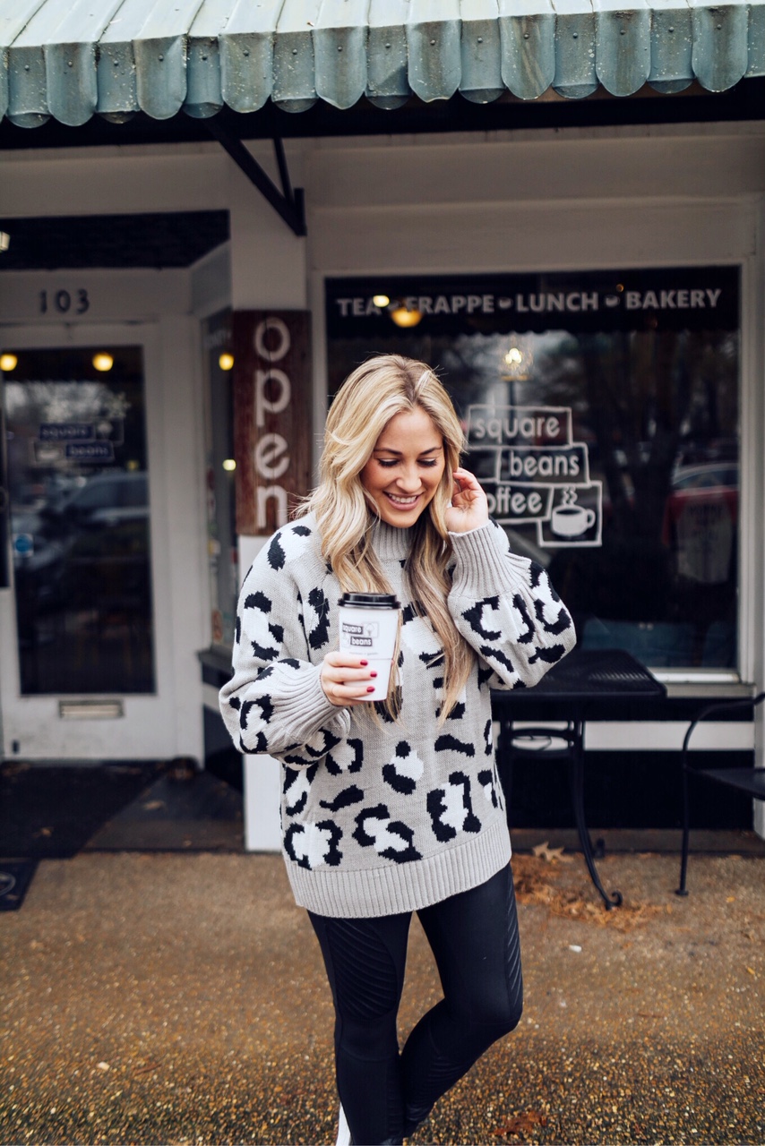 Casual winter wear styled by top US fashion blog, Walking in Memphis in High Heels: image of a woman wearing SPANX faux leather leggings, Pink Lily leopard print sweater, Adidas pink sneakers and faux fur double pom beanie hat