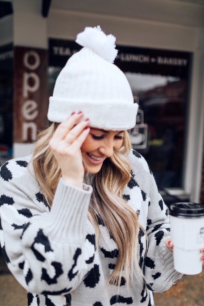 Casual winter wear styled by top US fashion blog, Walking in Memphis in High Heels: image of a woman wearing SPANX faux leather leggings, Pink Lily leopard print sweater, Adidas pink sneakers and faux fur double pom beanie hat