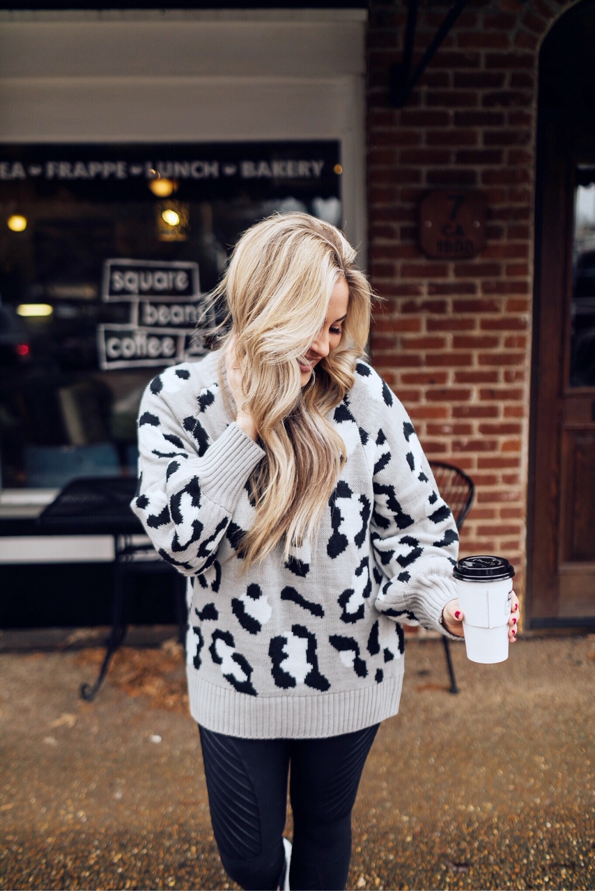 Casual winter wear styled by top US fashion blog, Walking in Memphis in High Heels: image of a woman wearing SPANX faux leather leggings, Pink Lily leopard print sweater, Adidas pink sneakers and faux fur double pom beanie hat