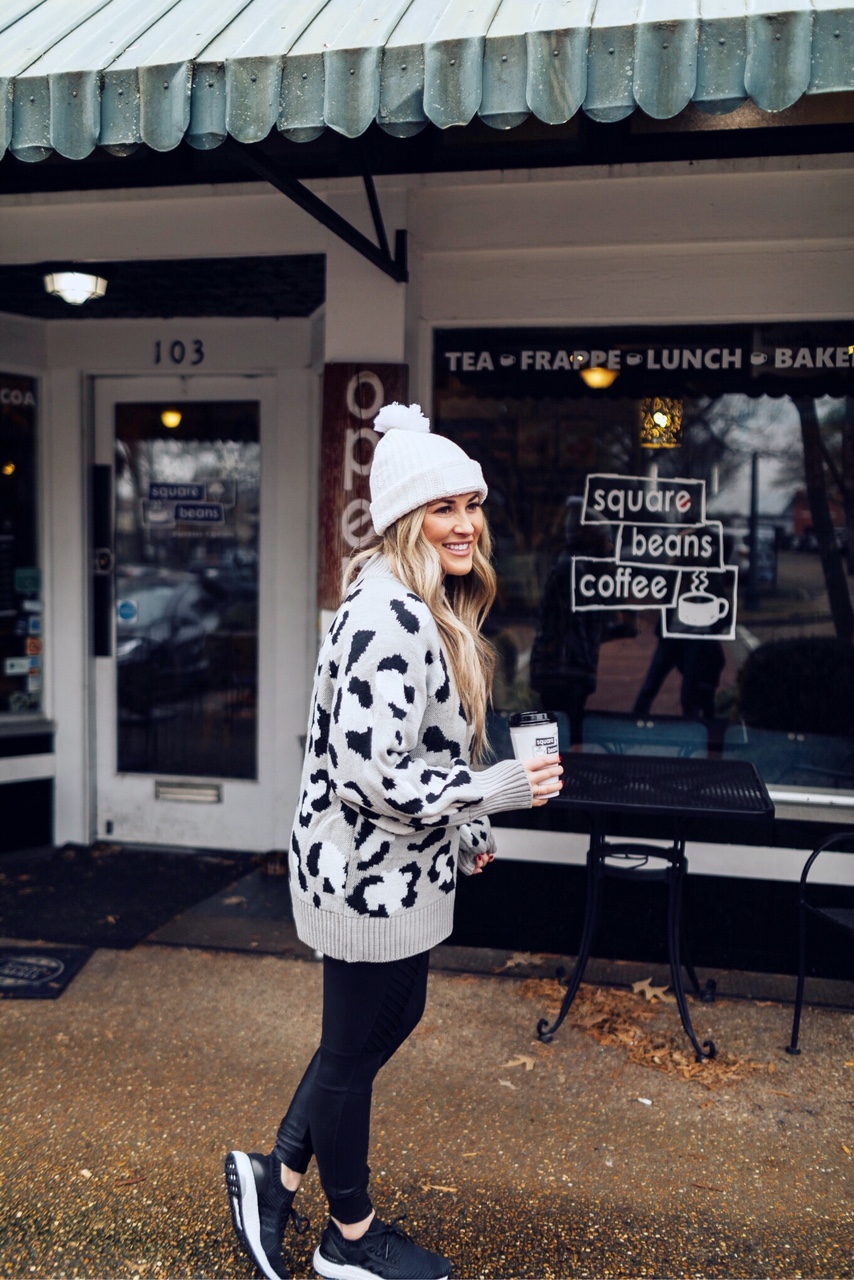 Casual winter wear styled by top US fashion blog, Walking in Memphis in High Heels: image of a woman wearing SPANX faux leather leggings, Pink Lily leopard print sweater, Adidas pink sneakers and faux fur double pom beanie hat