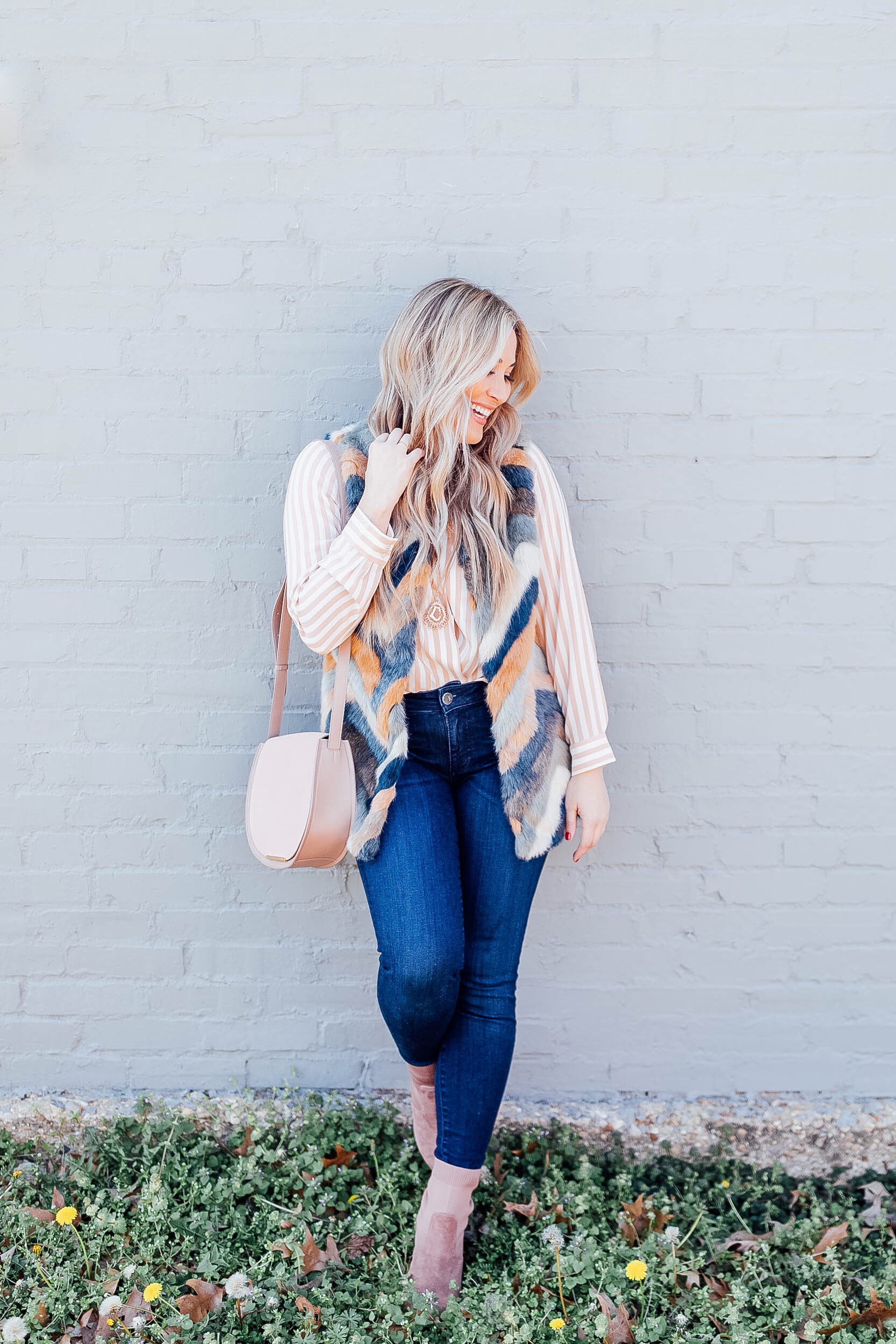 Top US fashion blog, Walking in Memphis in High Heels features their tips for mixing prints: image of a woman wearing a Pink Lily faux fur vest, a Cuyana silk cami, KUT from the Kloth skinny ankle jeans, Steve Madden suede booties and a Cuyana bag