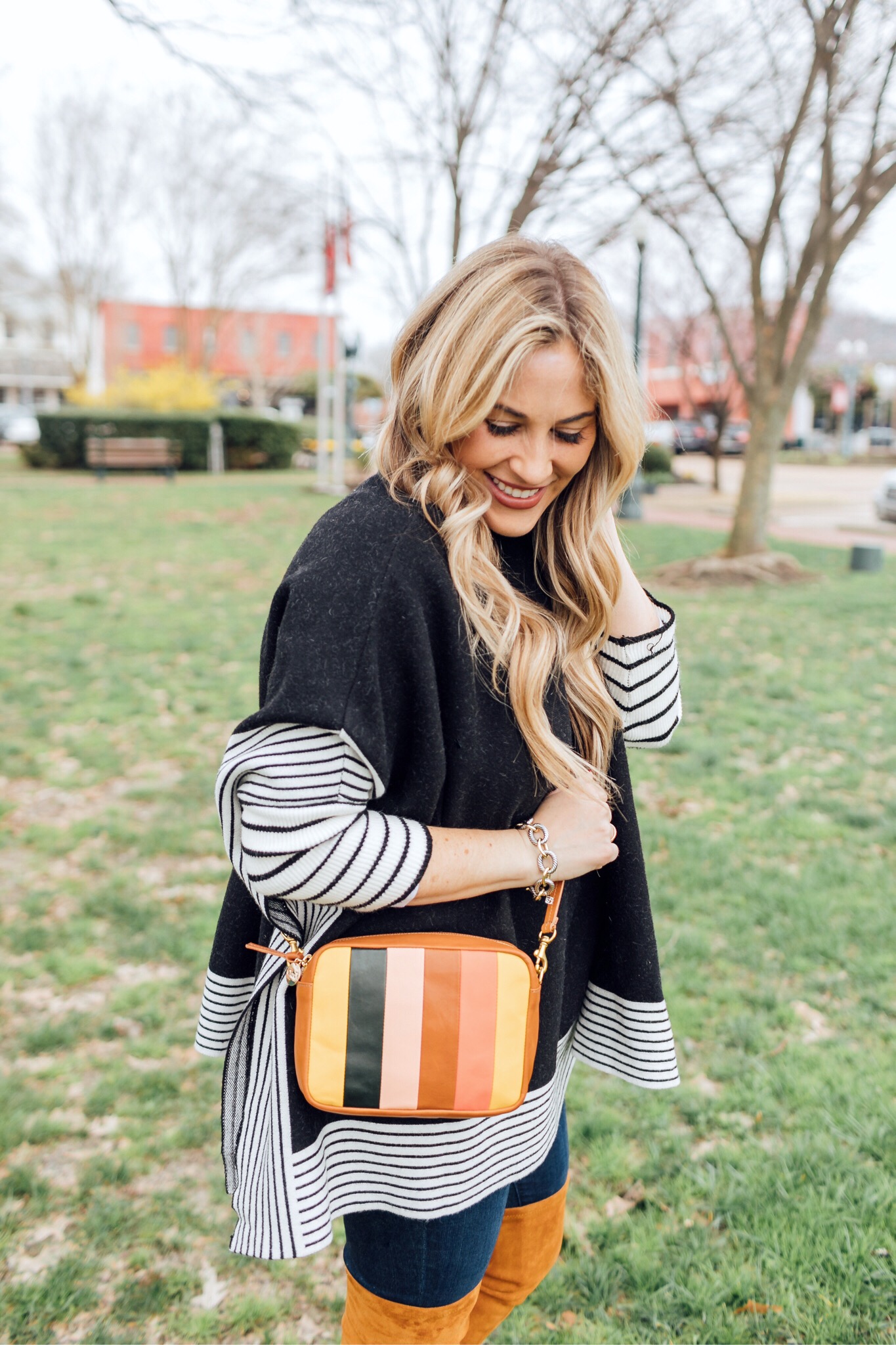 Colorful outfit featured by top US fashion blog, Walking in Memphis in High Heels: image of a woman wearing a Good American skinny jeans, a SheIn striped poncho jumper, Goodnight Macaroons suede over the knee boots and a Steve Madden crossbody bag