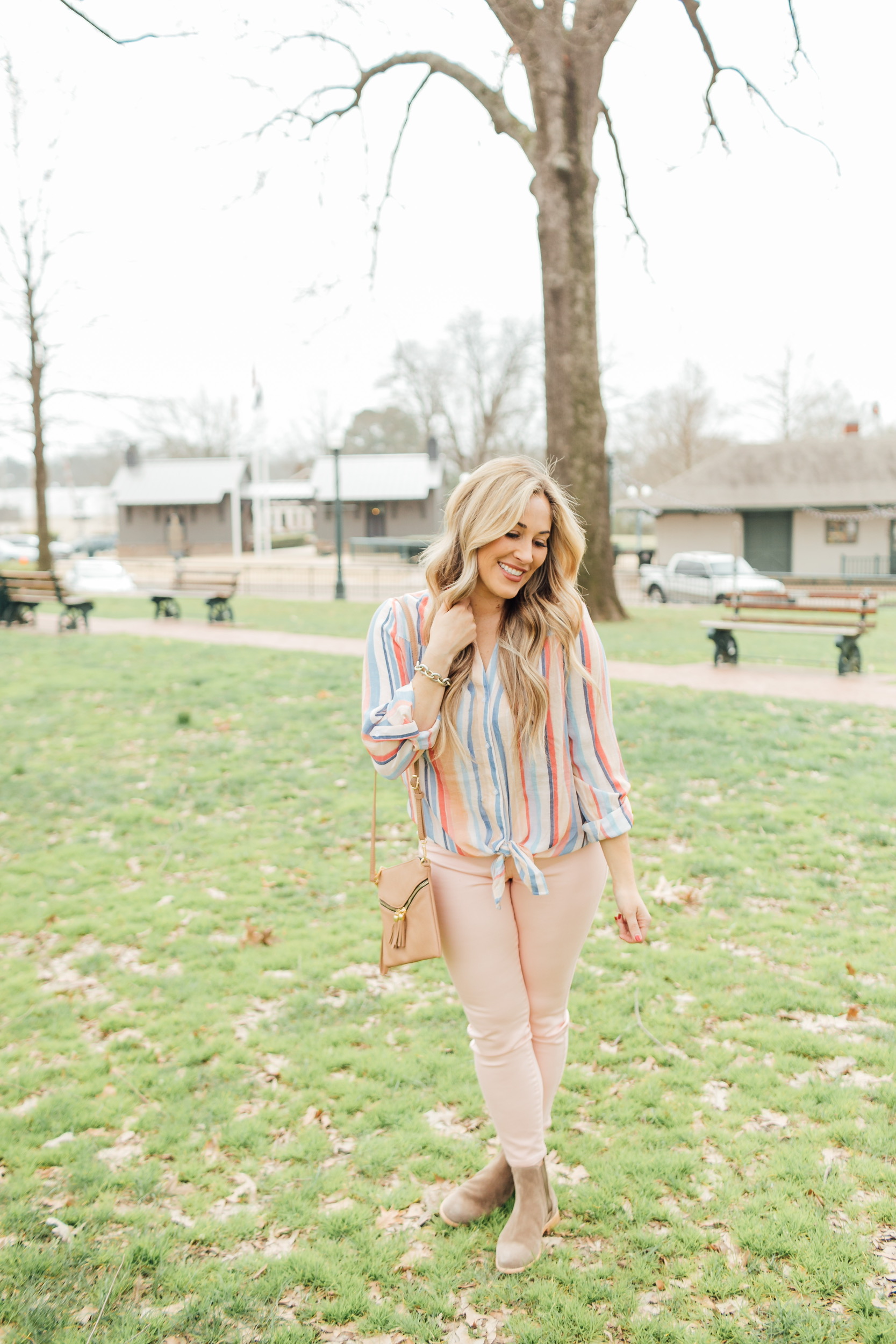 Spring outfit from Gordmans styled by top US fashion blog, Walking in Memphis in High Heels: image of a woman wearing peach jeans, striped button down shirt, and a crossbody bag