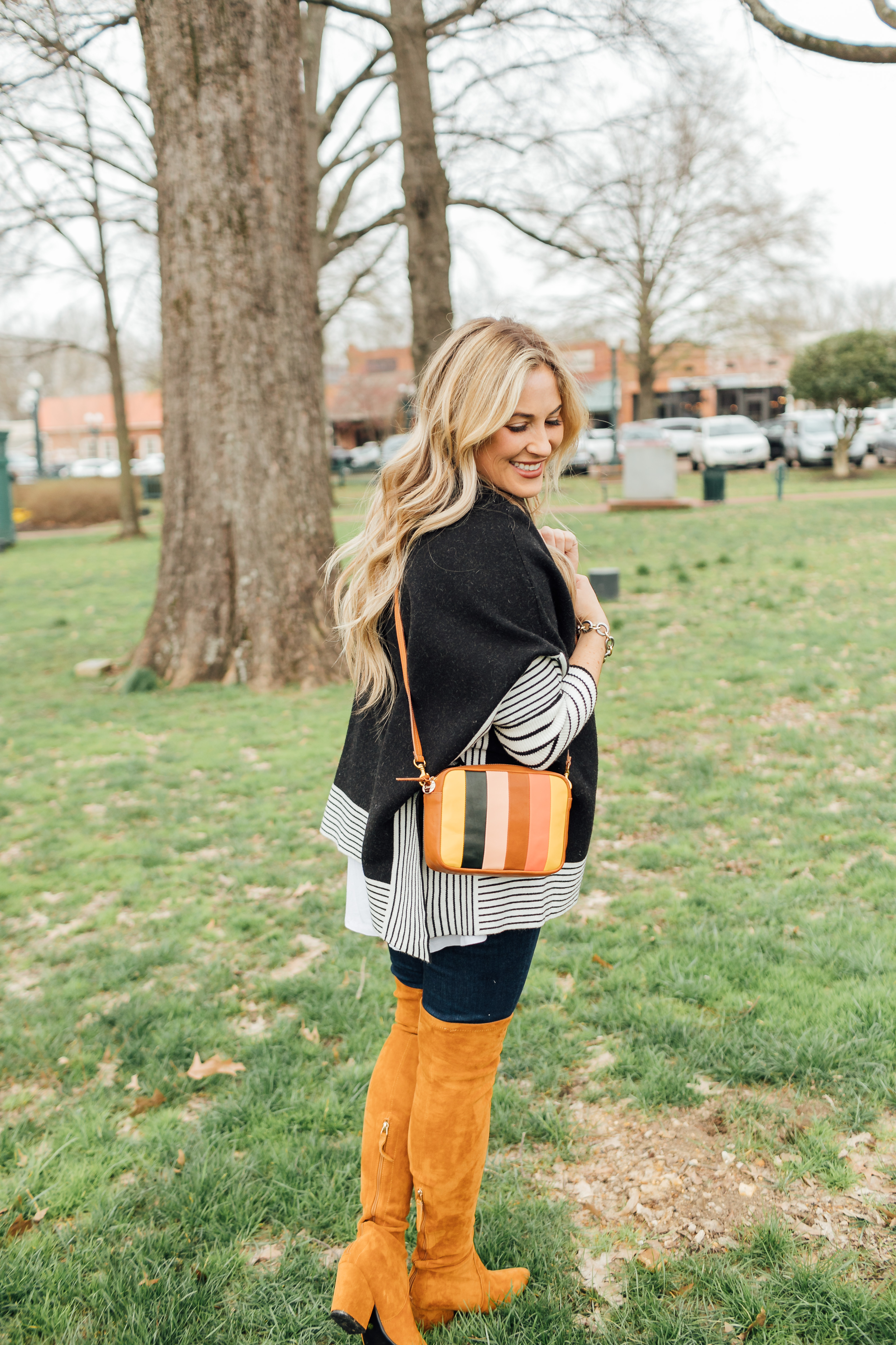 Colorful outfit featured by top US fashion blog, Walking in Memphis in High Heels: image of a woman wearing a Good American skinny jeans, a SheIn striped poncho jumper, Goodnight Macaroons suede over the knee boots and a Steve Madden crossbody bag