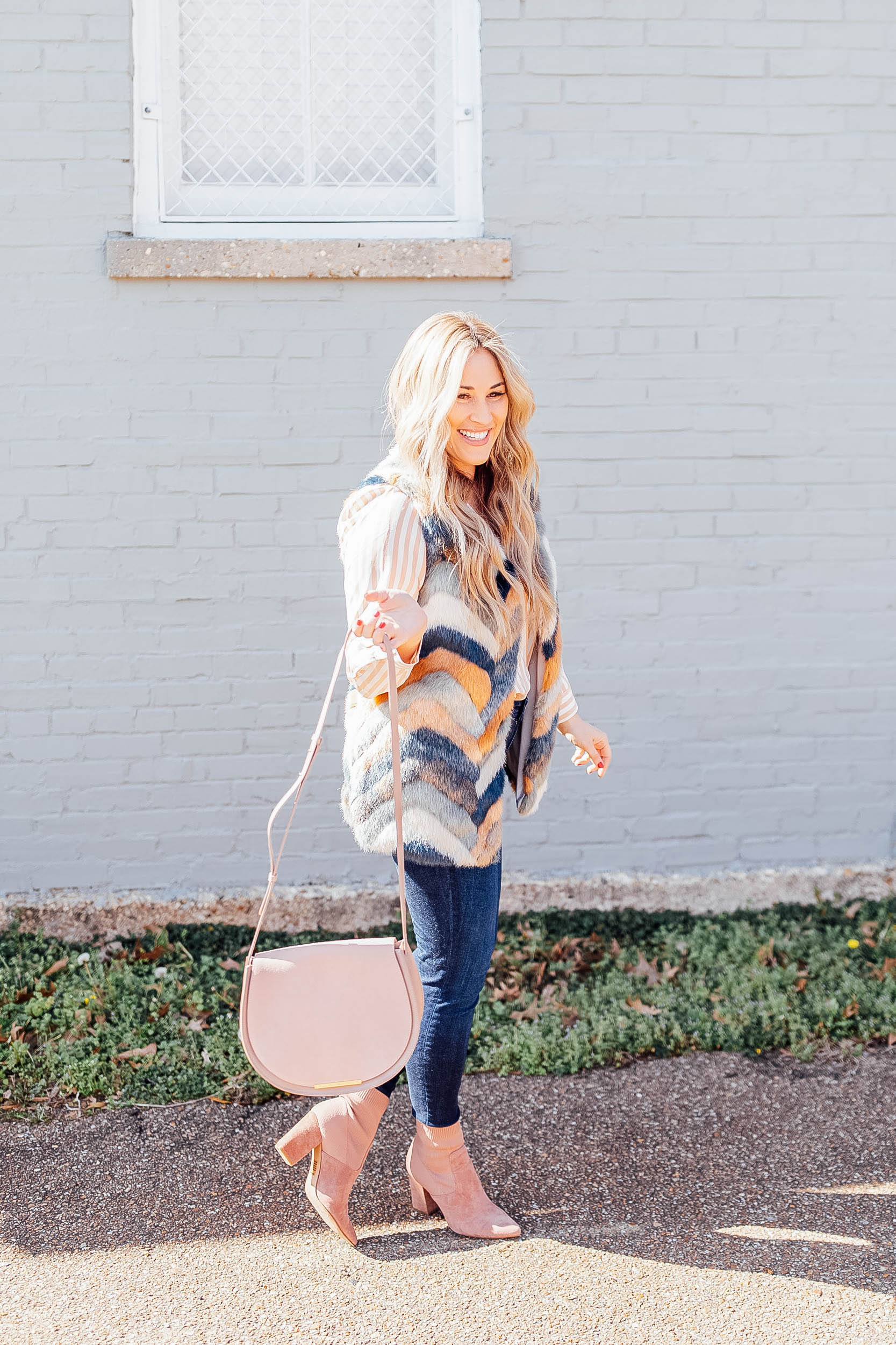 Top US fashion blog, Walking in Memphis in High Heels features their tips for mixing prints: image of a woman wearing a Pink Lily faux fur vest, a Cuyana silk cami, KUT from the Kloth skinny ankle jeans, Steve Madden suede booties and a Cuyana bag