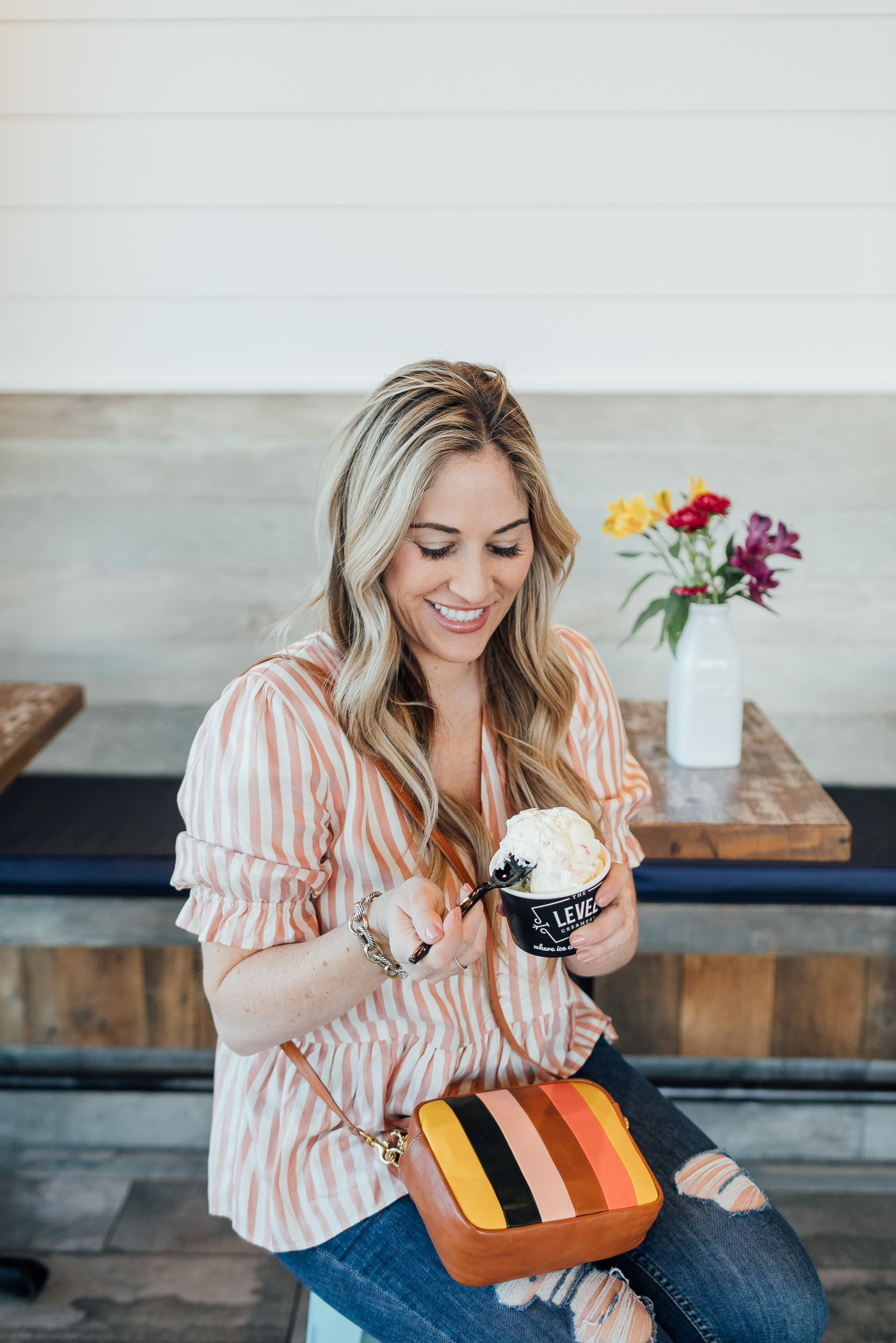 Madewell striped peplum top styled for Spring, featured by top US fashion blog, Walking in Memphis in High Heels: image of a woman wearing a Madewell top, Free People skinny jeans, Zappos sandals, and a Steve Madden crossbody bag.