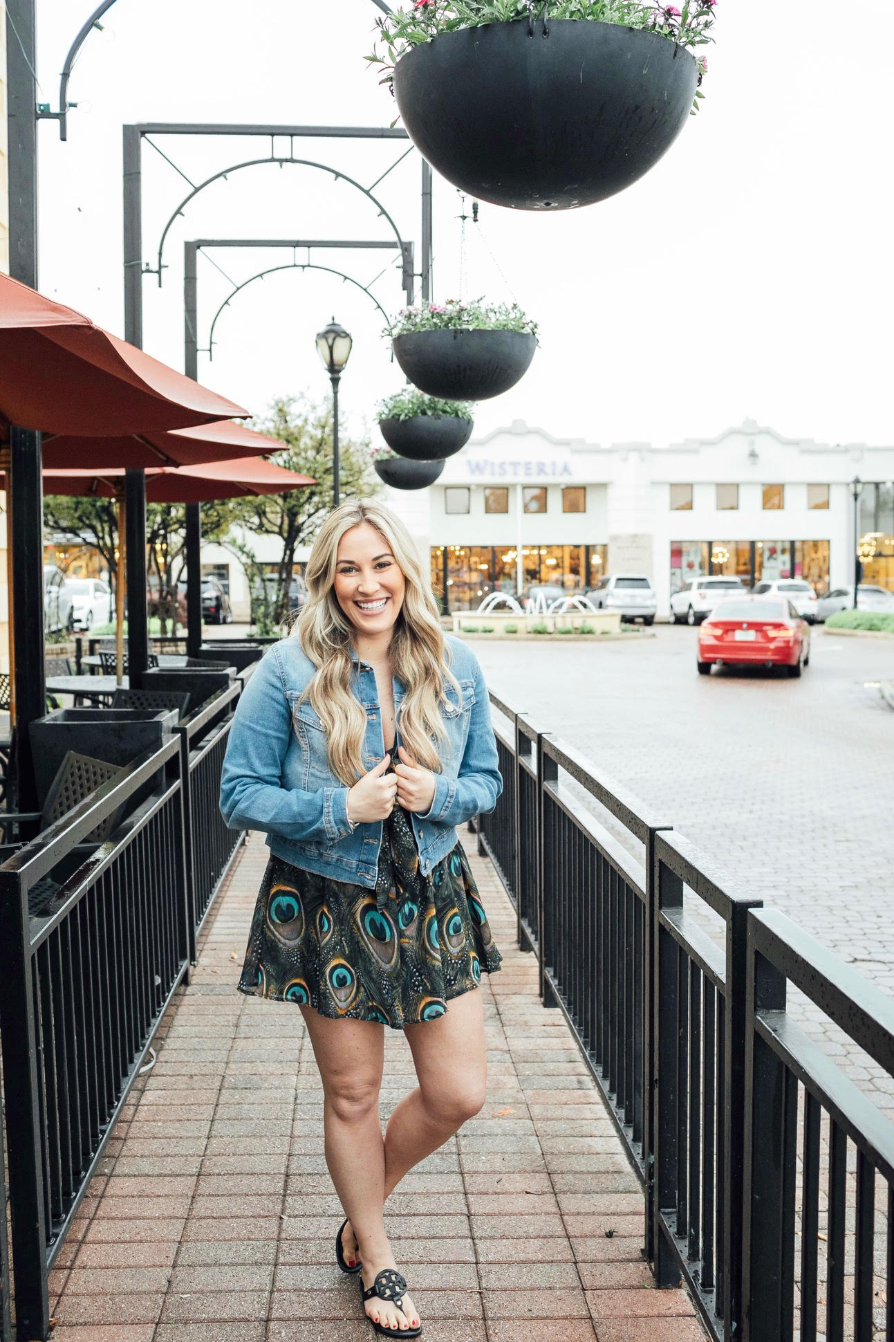 Casual summer look featured by top US fashion blog, Walking in Memphis in High Heels: image of a woman wearing a Red Dress Boutique peacock romper, Sofia Jeans by Sofia Vergara denim jacket, and Tory Burch flip flops