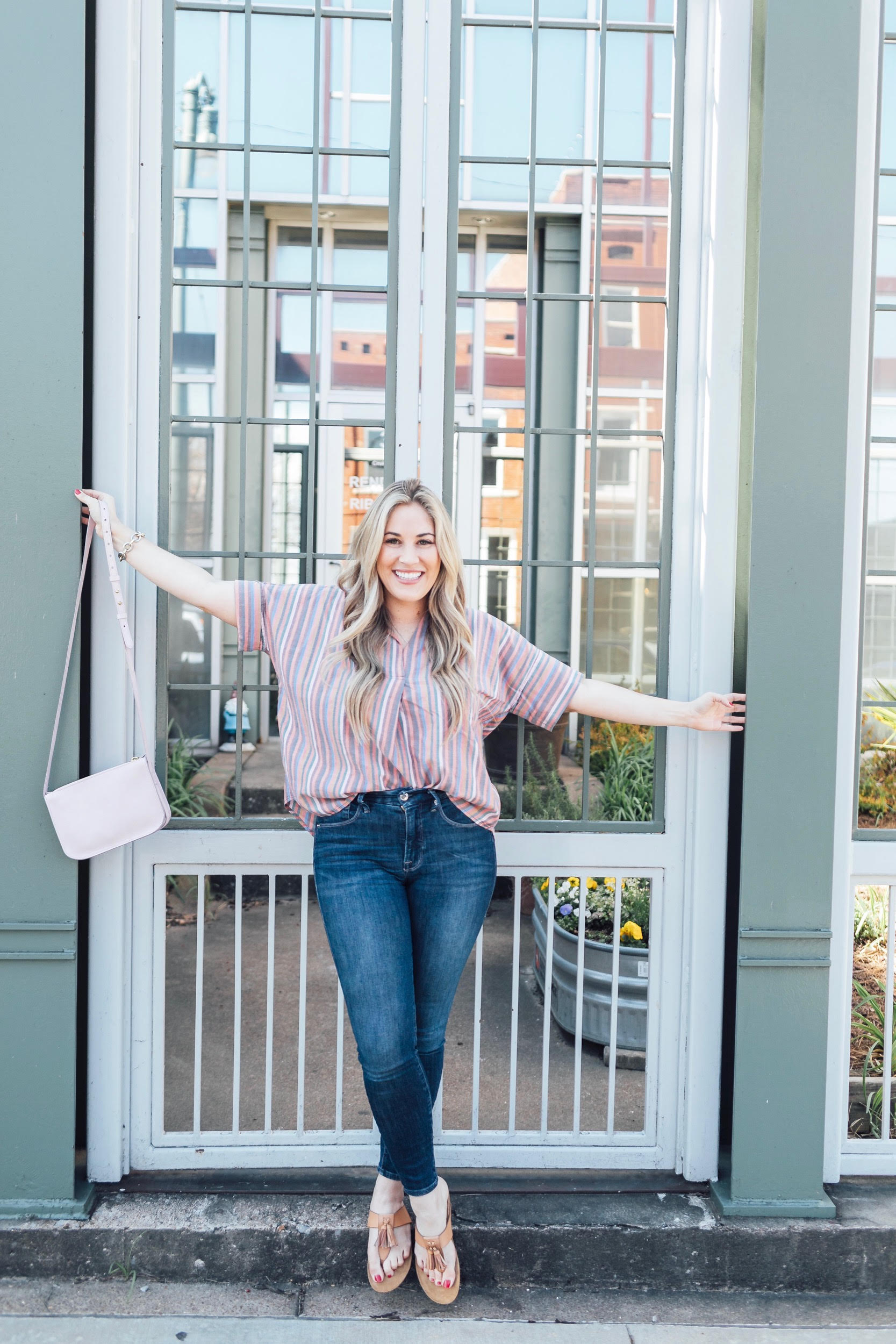 Comfortiva Gella tassel sandals style by top US fashion blog, Walking in Memphis in High Heels: image of a woman wearing a Madewell striped shirt, Good American skinny jeans, a Madewell crossbody bag, and Comfortiva Gella tassel sandals