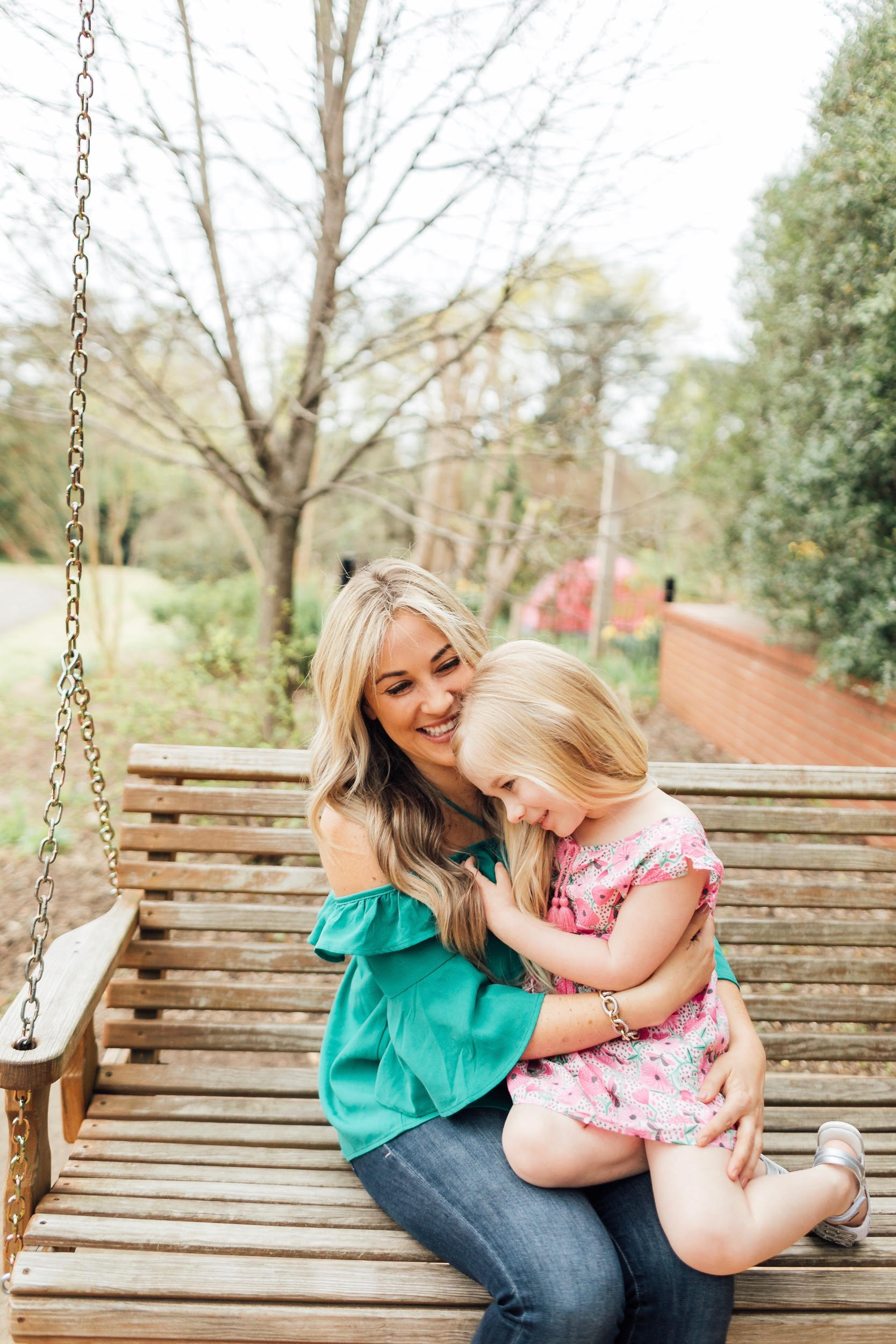 How to Get Cute Family Pictures with Your Child featured by top US life and style blog, Walking in Memphis in High Heels: image of a woman wearing a BB Dakota off the shoulder blouse, Good American skinny jeans, Tory Burch flies flops and her daughter wearing an Egg Baby floral dress and Pediped silver sandals