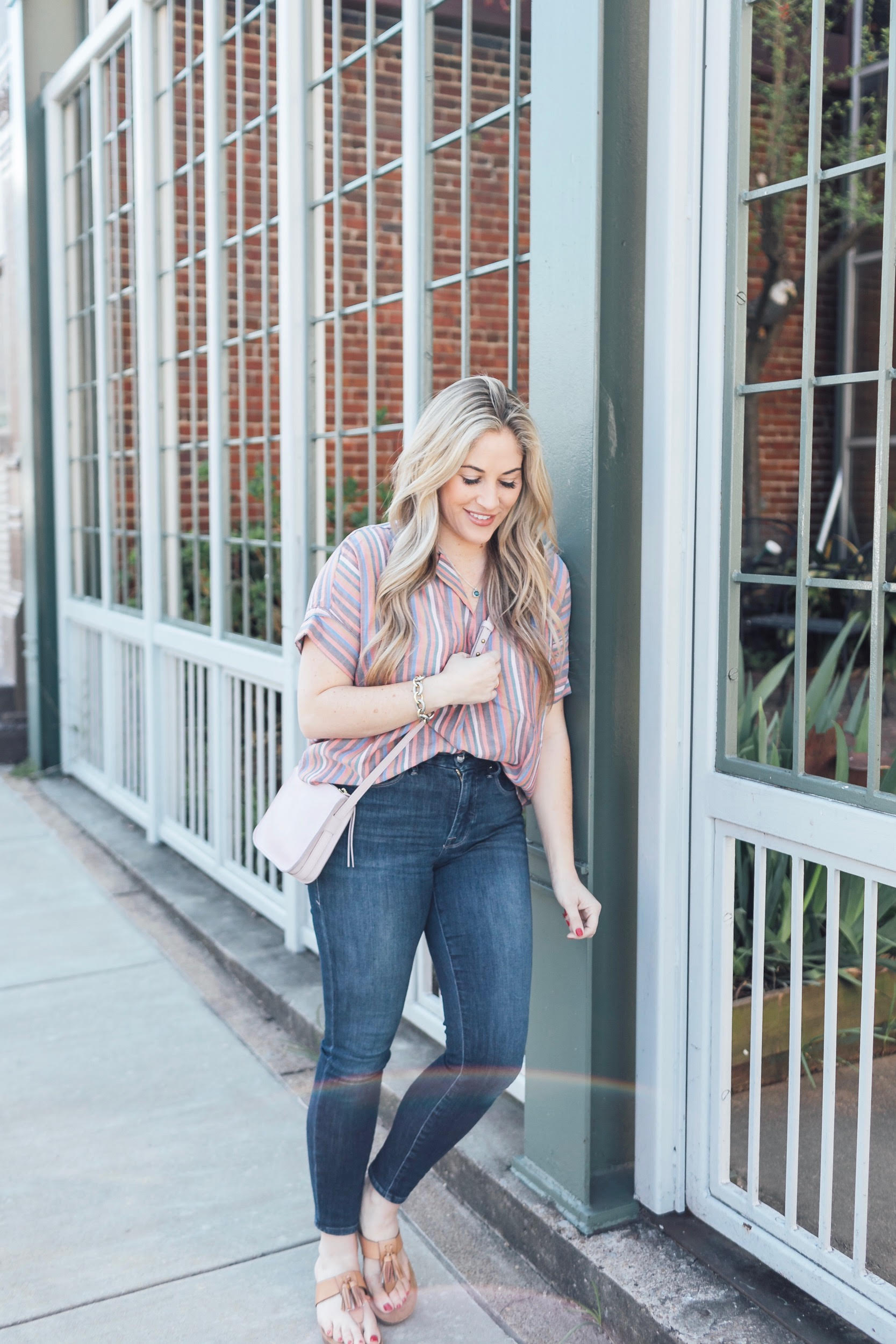 Comfortiva Gella tassel sandals style by top US fashion blog, Walking in Memphis in High Heels: image of a woman wearing a Madewell striped shirt, Good American skinny jeans, a Madewell crossbody bag, and Comfortiva Gella tassel sandals