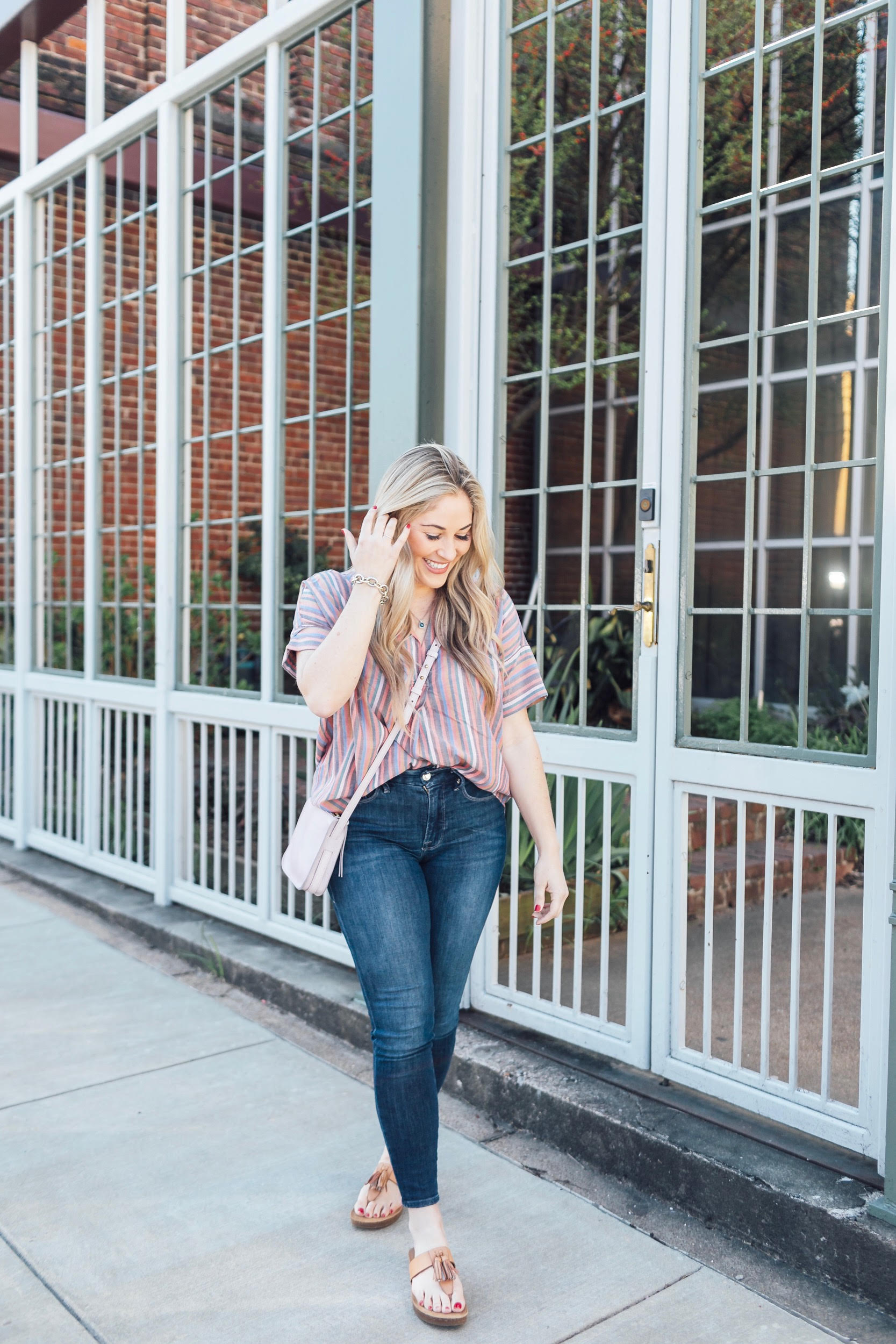 Comfortiva Gella tassel sandals style by top US fashion blog, Walking in Memphis in High Heels: image of a woman wearing a Madewell striped shirt, Good American skinny jeans, a Madewell crossbody bag, and Comfortiva Gella tassel sandals