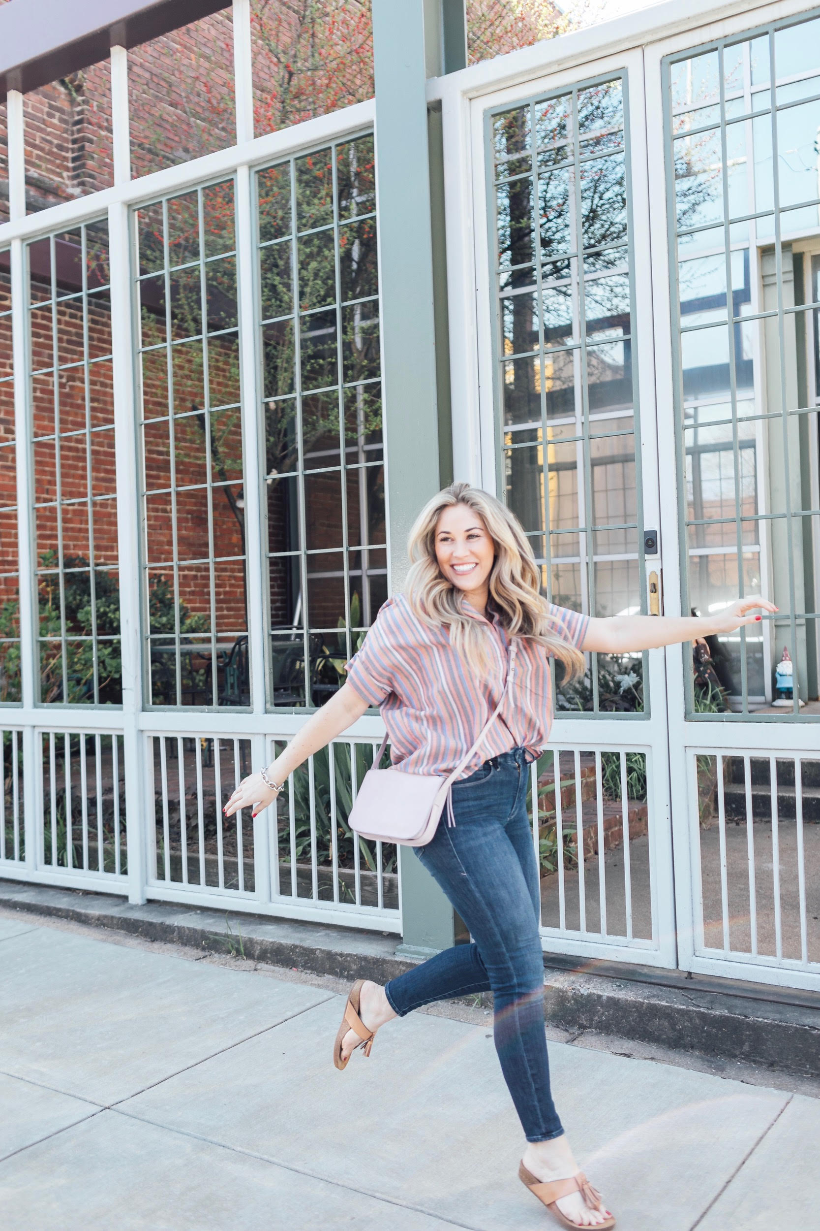 Comfortiva Gella tassel sandals style by top US fashion blog, Walking in Memphis in High Heels: image of a woman wearing a Madewell striped shirt, Good American skinny jeans, a Madewell crossbody bag, and Comfortiva Gella tassel sandals