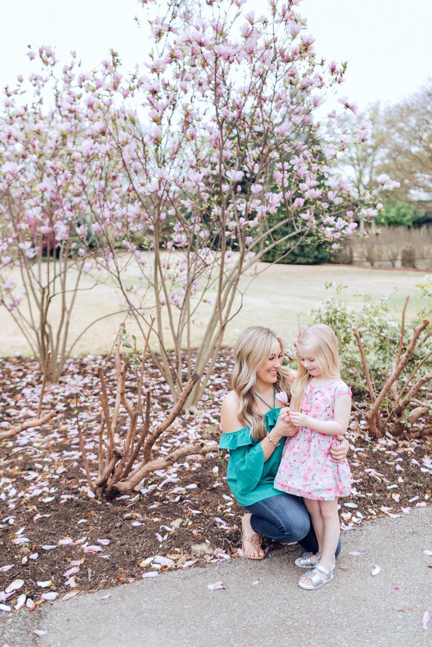 How to Get Cute Family Pictures with Your Child featured by top US life and style blog, Walking in Memphis in High Heels: image of a woman wearing a BB Dakota off the shoulder blouse, Good American skinny jeans, Tory Burch flies flops and her daughter wearing an Egg Baby floral dress and Pediped silver sandals