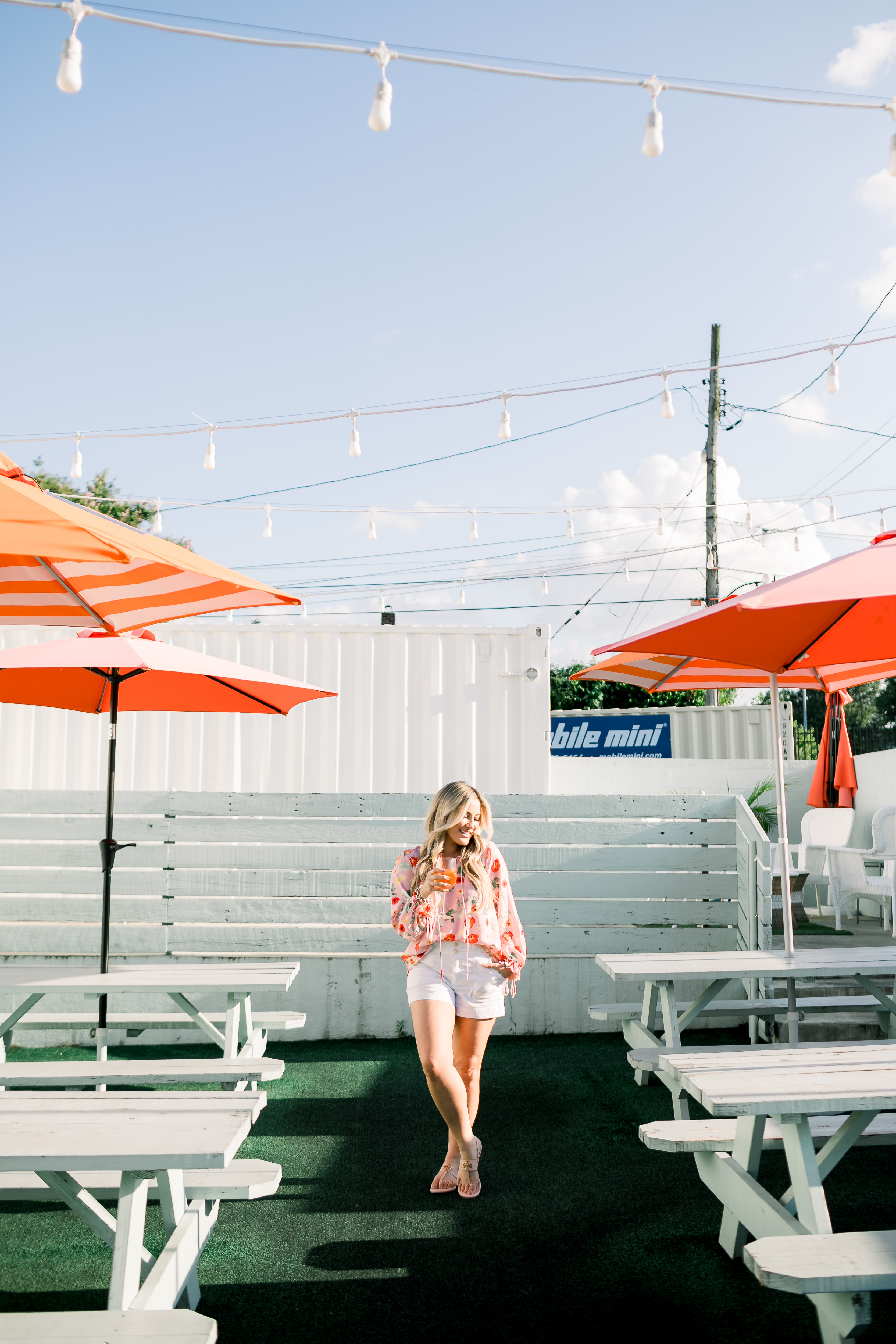 Bright summer colors fashion featured by top US fashion blog, Walking in Memphis in High Heels: image of a woman wearing a Gibson & Latimer floral shirt, Anthropologie high waisted white denim shorts, Tory Burch Miller flip flops and a David Yurman bracelet