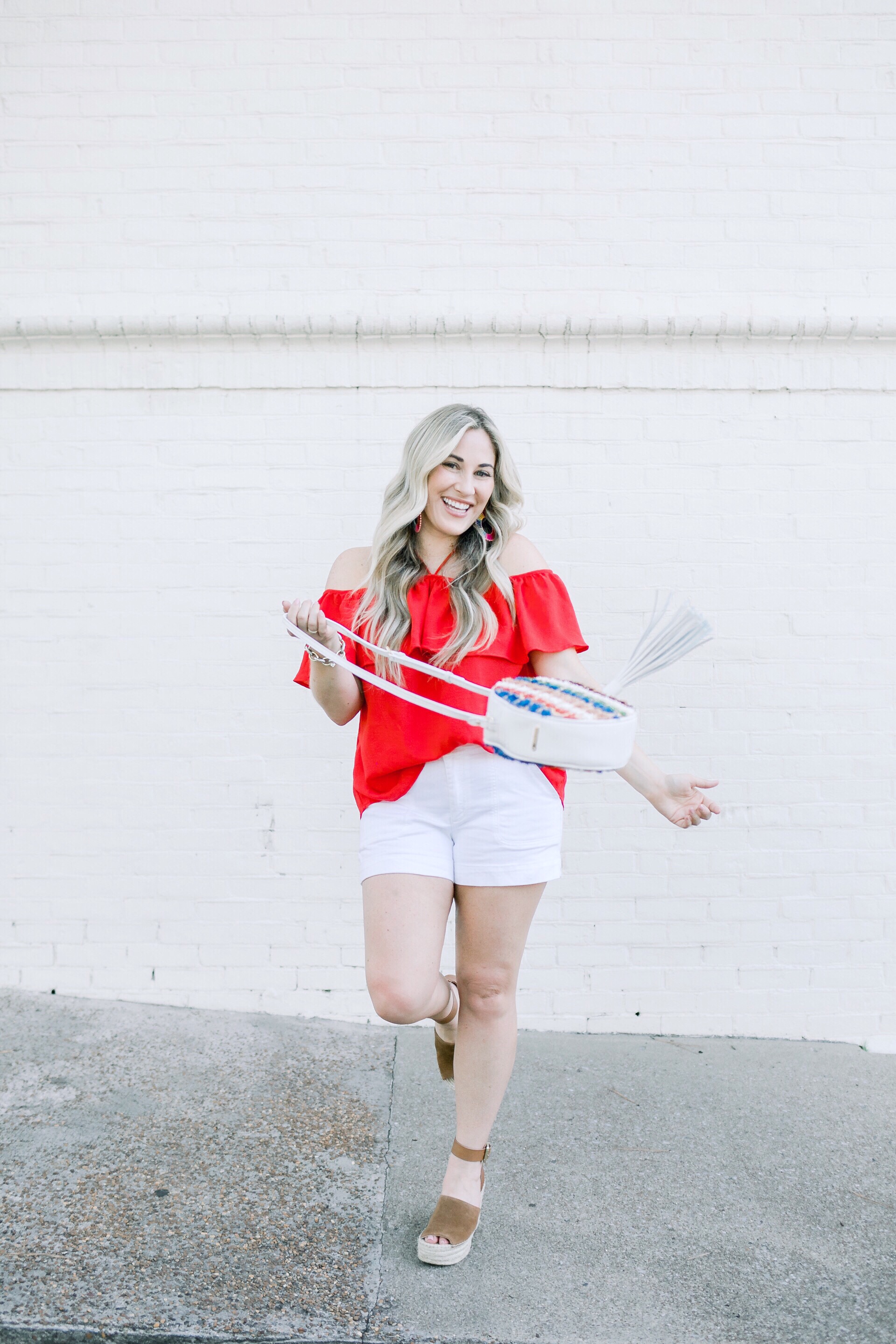 Labor Day Looks featured by top US fashion blog, Walking in Memphis in High Heels: image of a woman wearing a BB Dakota off the shoulder red top, Anthropologie palazzo shorts, Marc Fisher platform wedge sandals, Gigi New York raffia crossbody bag, Baublebar raffia statement earrings.