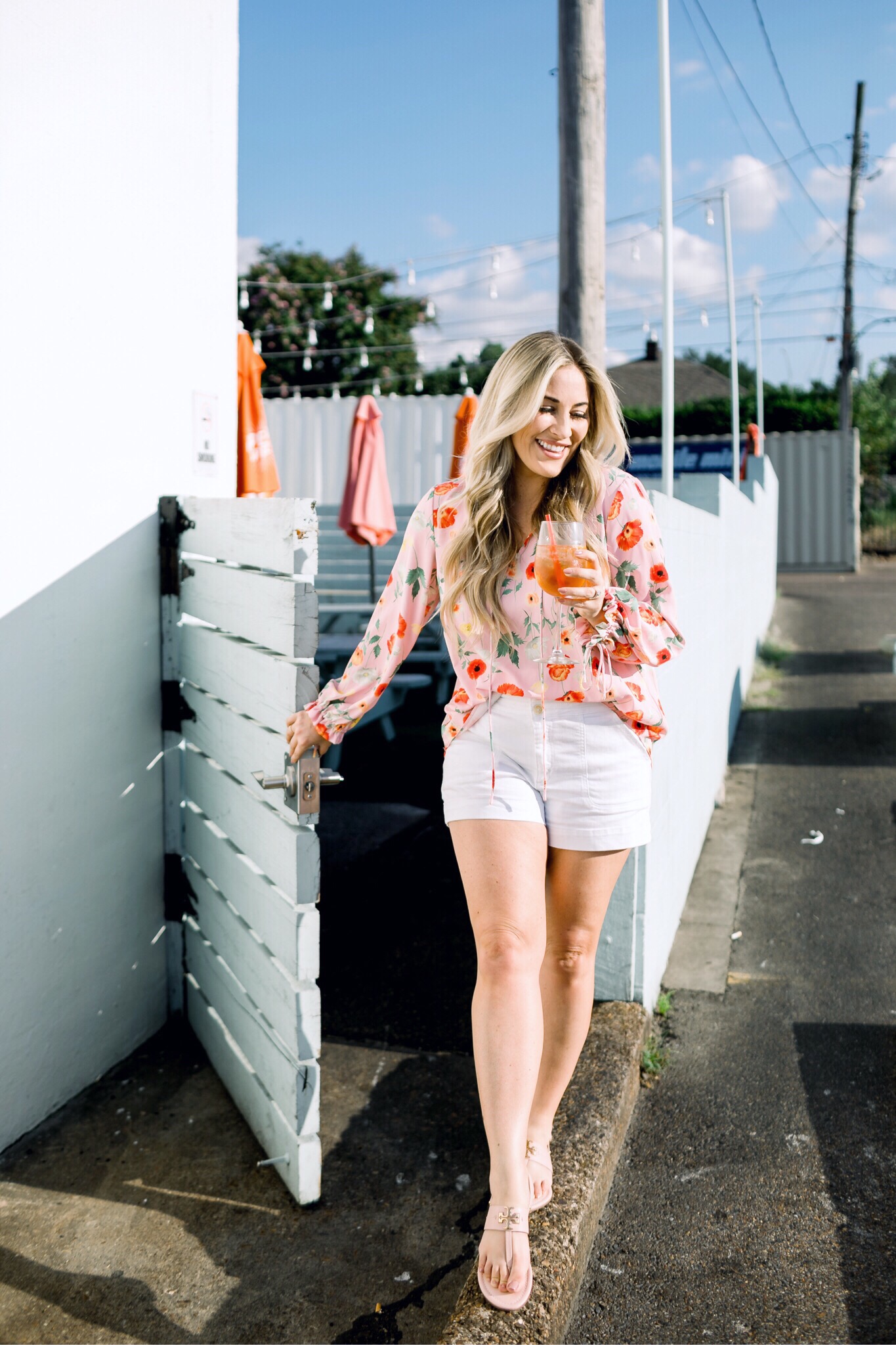 Bright summer colors fashion featured by top US fashion blog, Walking in Memphis in High Heels: image of a woman wearing a Gibson & Latimer floral shirt, Anthropologie high waisted white denim shorts, Tory Burch Miller flip flops and a David Yurman bracelet