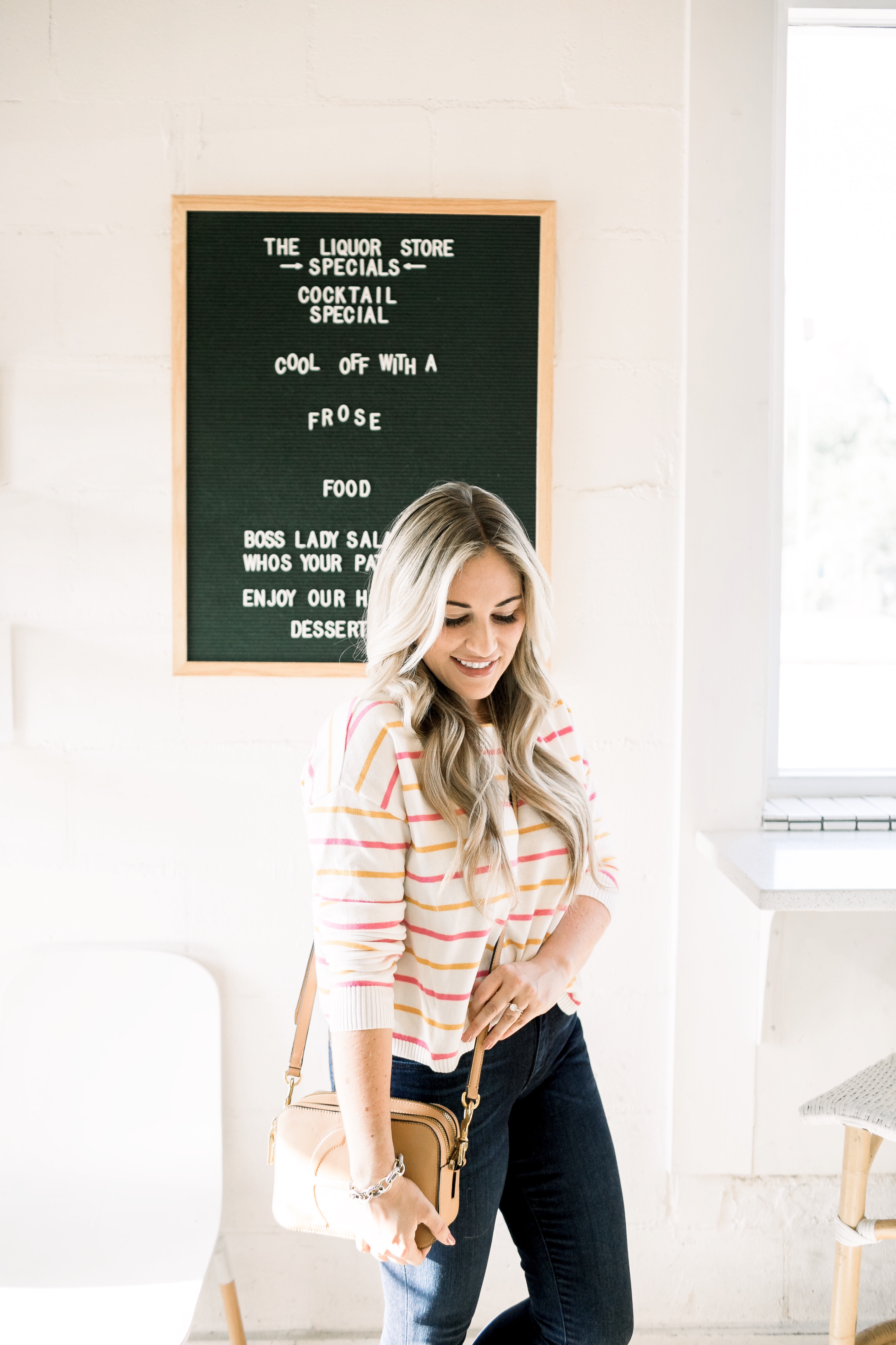 Cute summer to fall casual look styled by top US fashion blog, Walking in Memphis in High Heels: image of a woman wearing a Pink Lily Boutique striped sweater, Good American high waisted skinny jeans, and Tory Burch sandals.