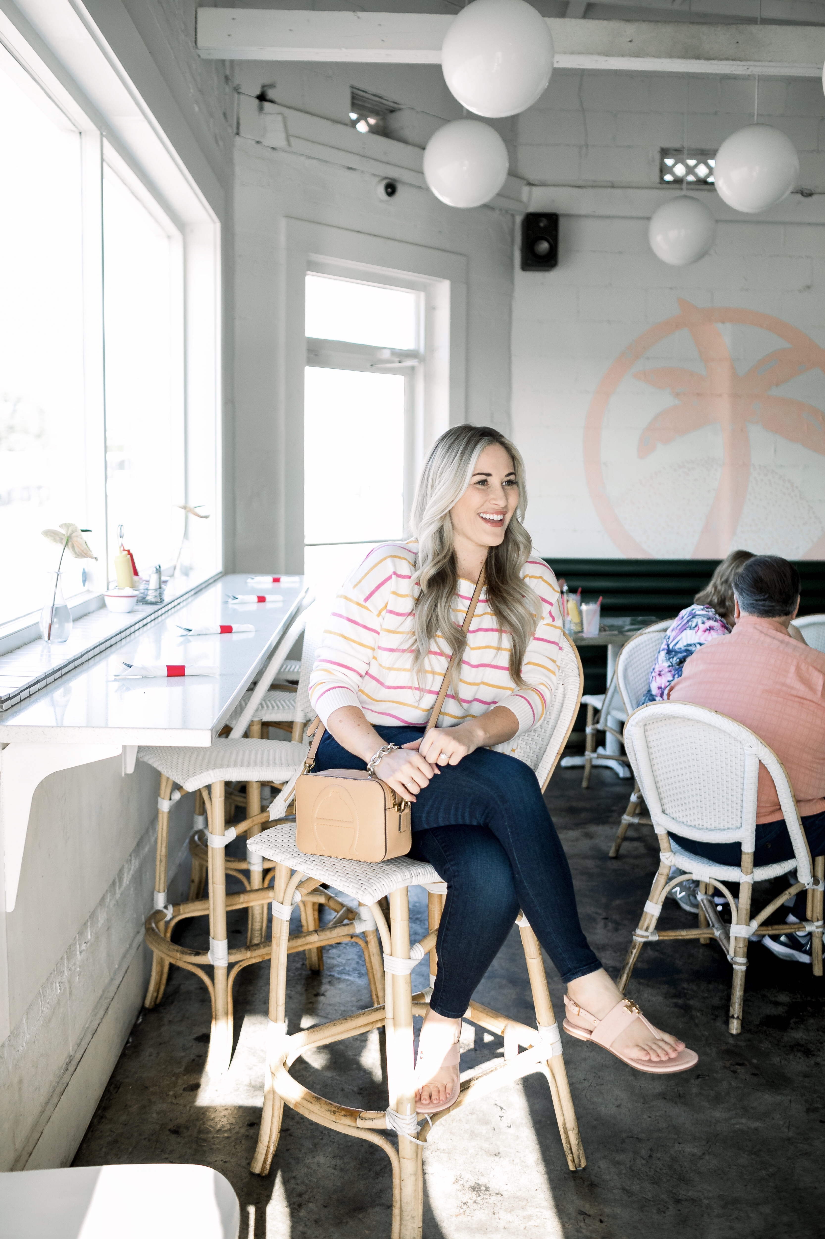 Cute summer to fall casual look styled by top US fashion blog, Walking in Memphis in High Heels: image of a woman wearing a Pink Lily Boutique striped sweater, Good American high waisted skinny jeans, and Tory Burch sandals.