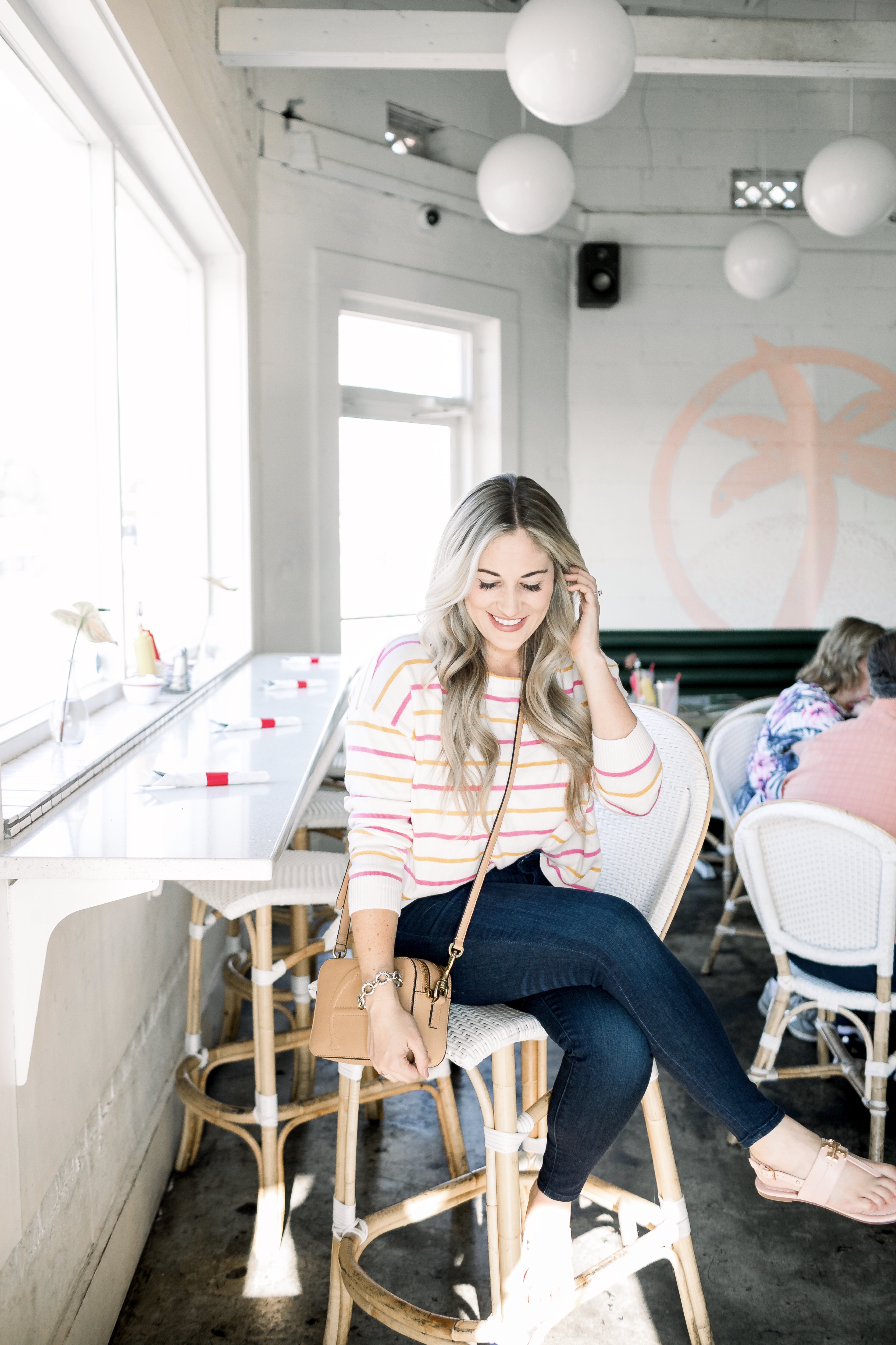 Cute summer to fall casual look styled by top US fashion blog, Walking in Memphis in High Heels: image of a woman wearing a Pink Lily Boutique striped sweater, Good American high waisted skinny jeans, and Tory Burch sandals.