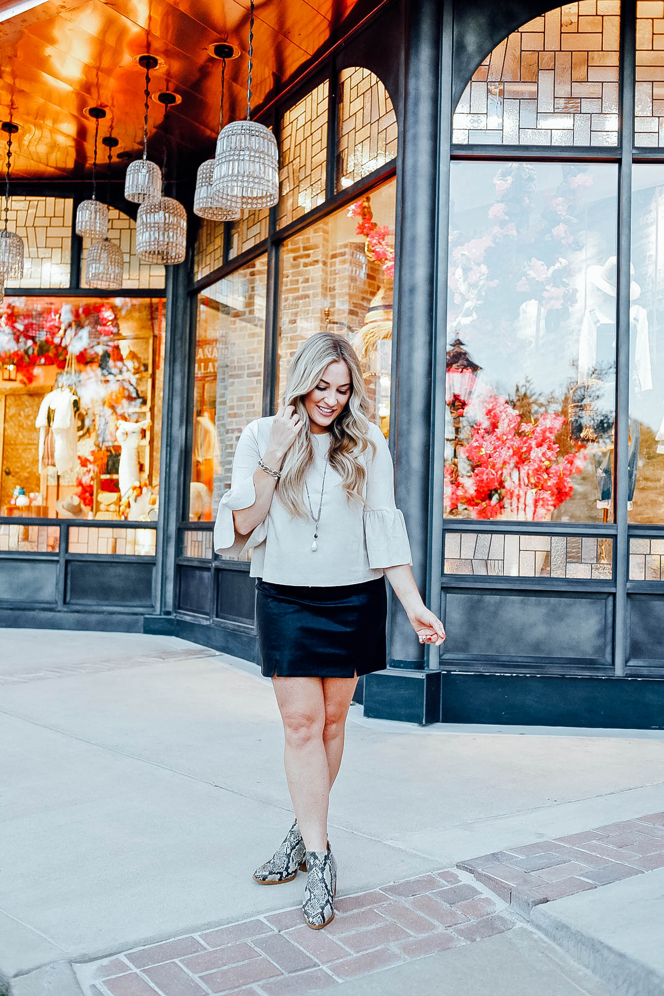 Fall Fashion Essentials featured by top US fashion blog, Walking in Memphis in High Heels: image of a woman wearing snakeskin leather booties, faux leather mini skirt, suede bell sleeve top from Altar'd Sata.