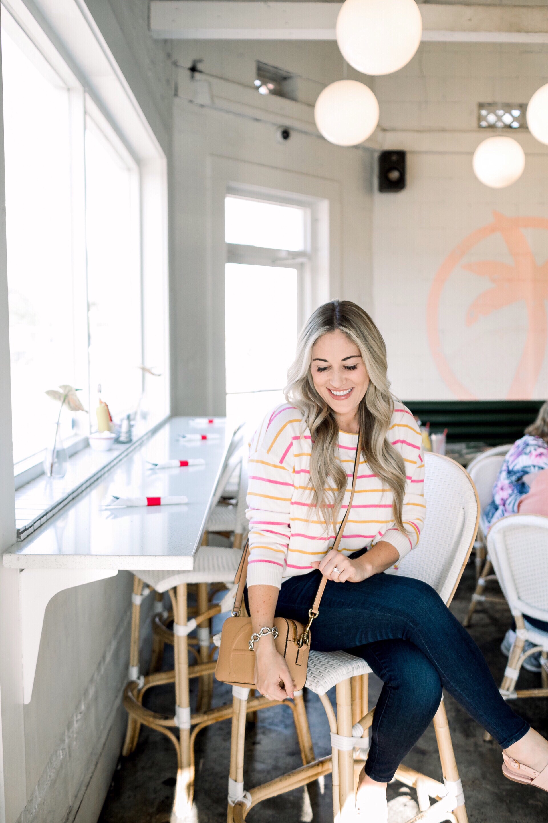 Cute summer to fall casual look styled by top US fashion blog, Walking in Memphis in High Heels: image of a woman wearing a Pink Lily Boutique striped sweater, Good American high waisted skinny jeans, and Tory Burch sandals.