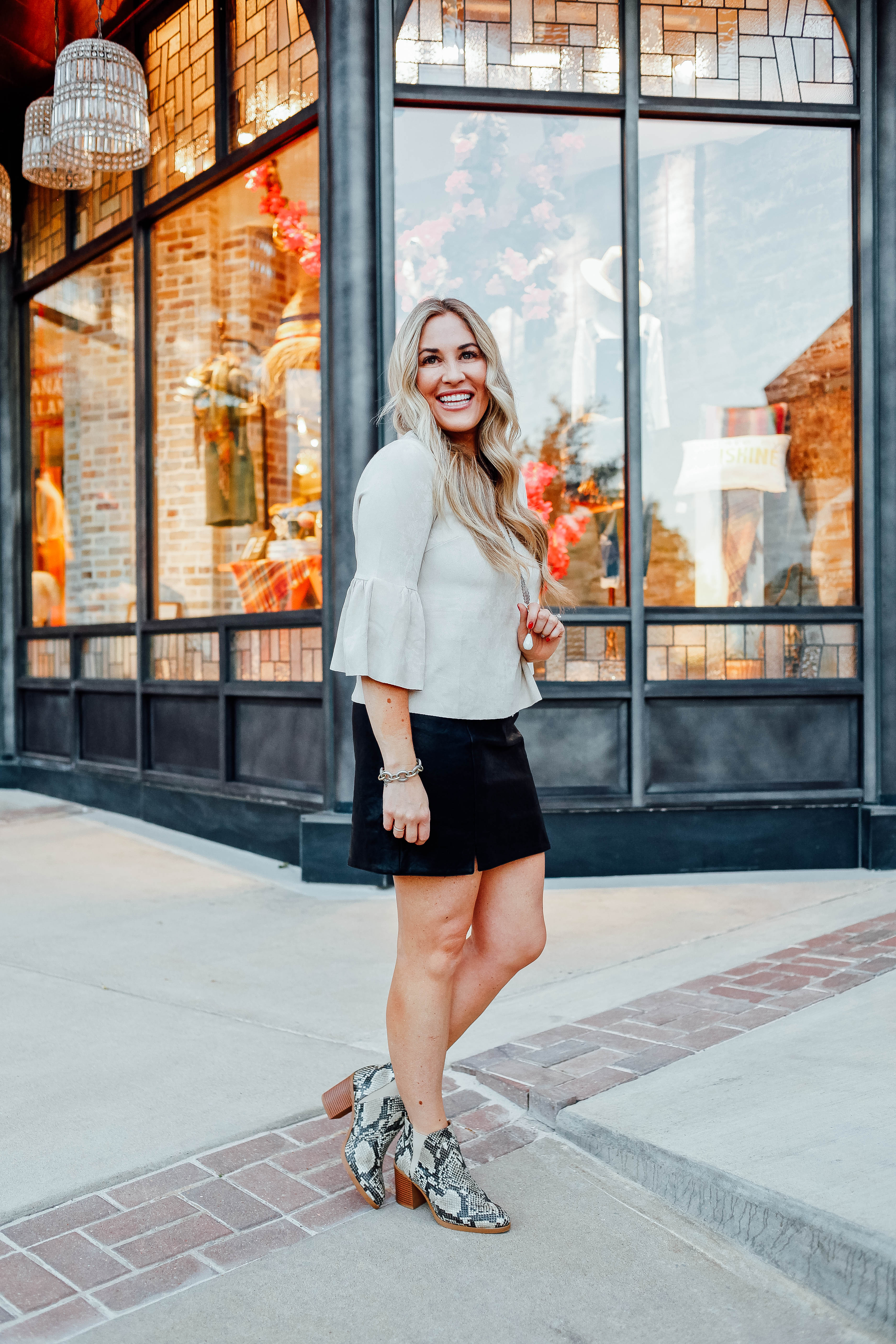 Fall Fashion Essentials featured by top US fashion blog, Walking in Memphis in High Heels: image of a woman wearing snakeskin leather booties, faux leather mini skirt, suede bell sleeve top from Altar'd Sata.