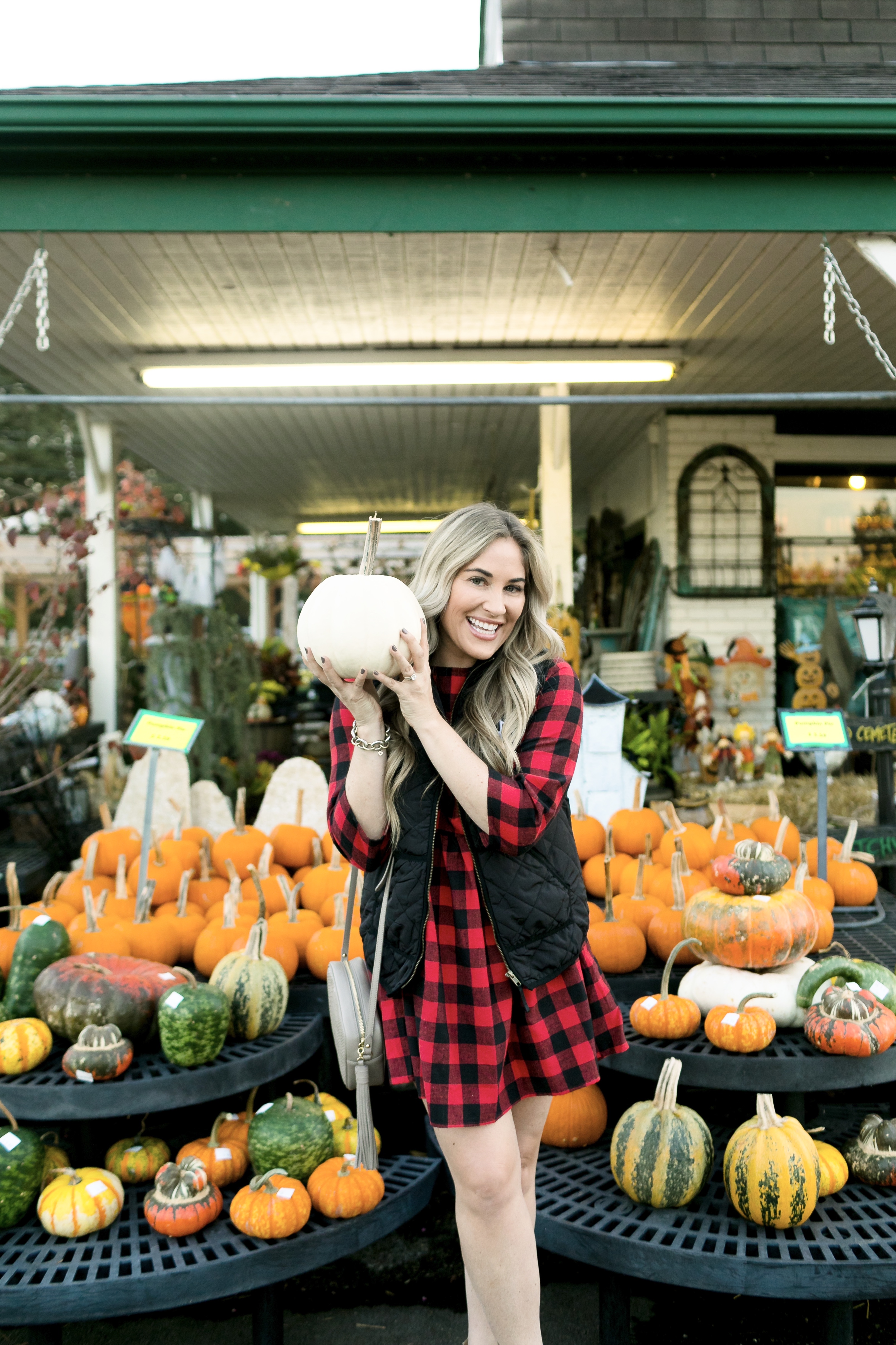 How to layer clothes in the fall, tips featured by top US fashion blog, Walking in Memphis in High Heels: image of a woman wearing a SheIn plaid smock dress, MarleyLilly monogrammed puffer vest, and Vince Camuto snakeskin booties.