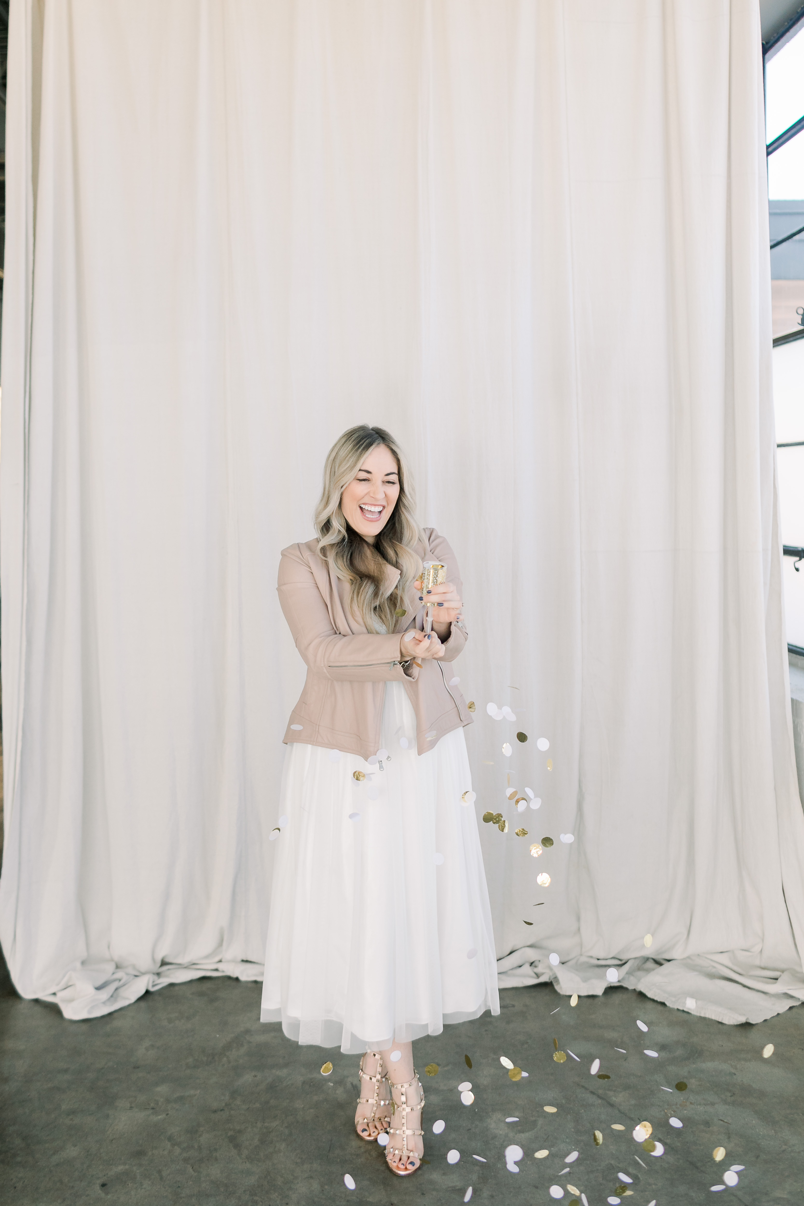 How to Dress up for the Holidays, styling tips featured by top US fashion blog, Walking in Memphis in High Heels: image of a woman wearing an Adrianna Papell tulle gown, BB Dakota faux leather Moto jacket, and Valentino Garavani block heel sandals.