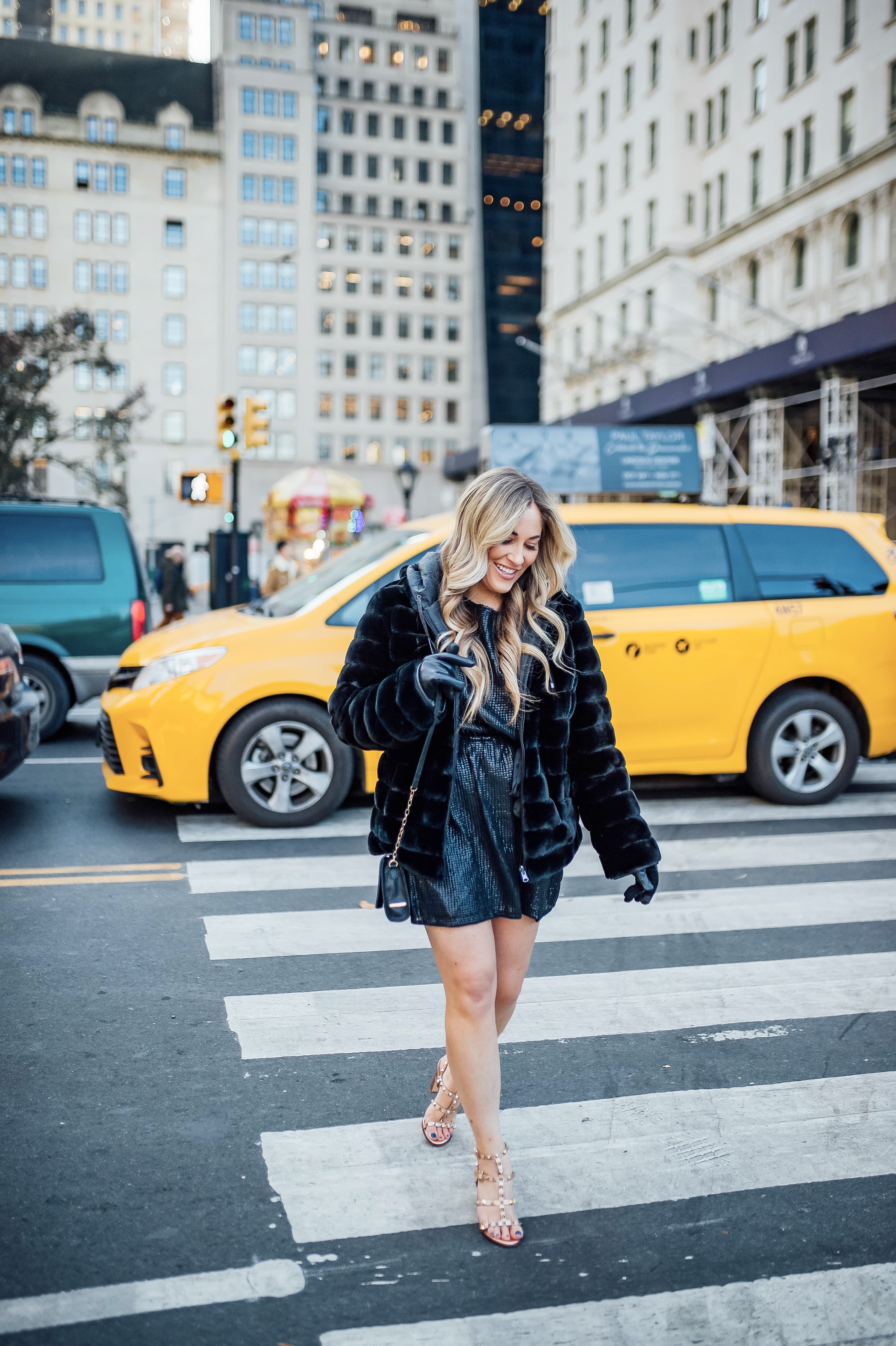 Holiday event style for NYE, Holiday Weddings, Holiday Parties featured by top US fashion blog, Walking in Memphis in High Heels: image of a woman wearing Lana A Boutique puffer jacket, Gigi New York crossbody bag, Valentino Garavani heeled sandals, Kohl’s faux fur leather tech gloves, and a Red Dress Boutique silver dress.