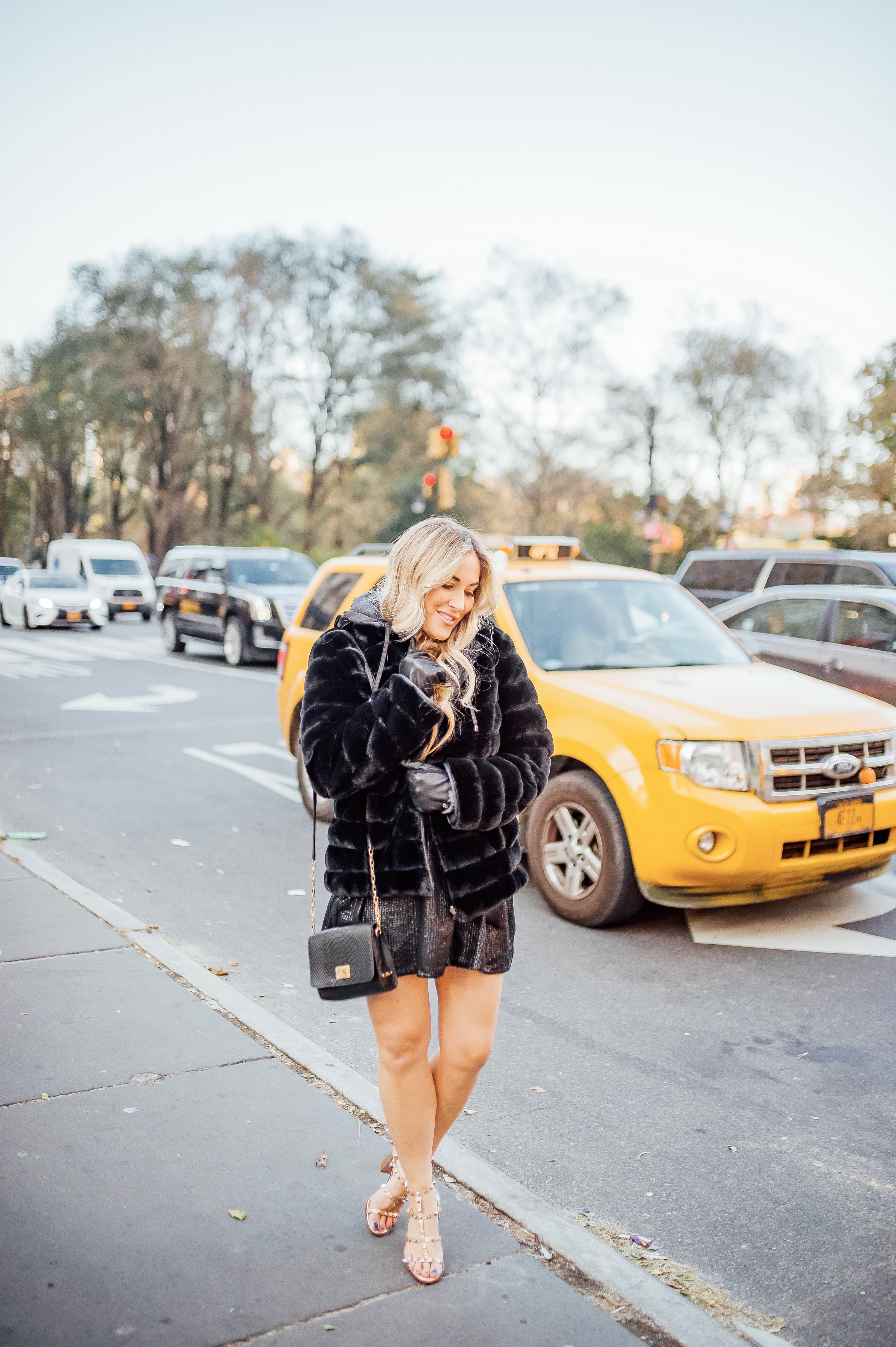 Holiday event style for NYE, Holiday Weddings, Holiday Parties featured by top US fashion blog, Walking in Memphis in High Heels: image of a woman wearing Lana A Boutique puffer jacket, Gigi New York crossbody bag, Valentino Garavani heeled sandals, Kohl’s faux fur leather tech gloves, and a Red Dress Boutique silver dress.