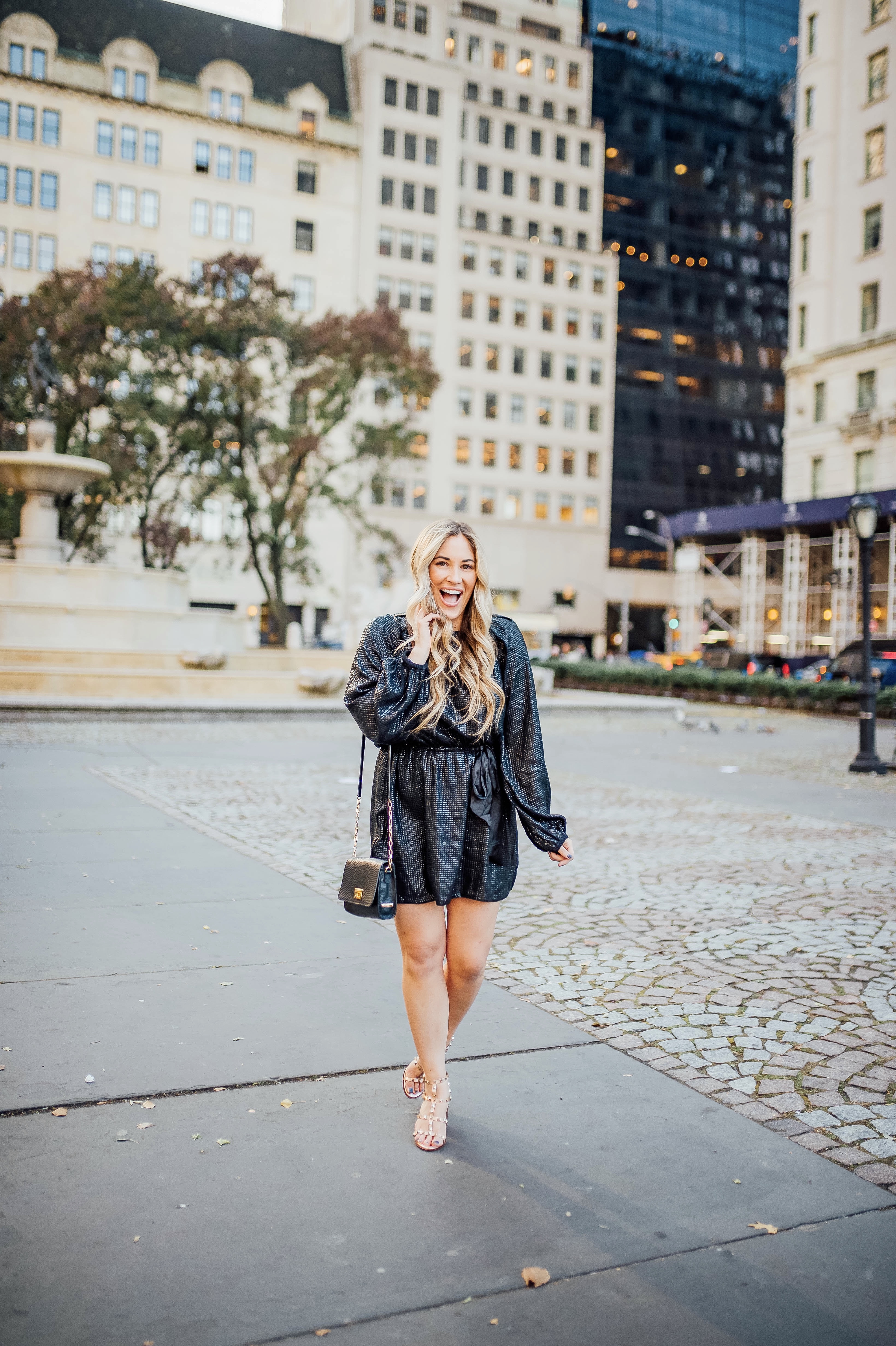 Holiday event style for NYE, Holiday Weddings, Holiday Parties featured by top US fashion blog, Walking in Memphis in High Heels: image of a woman wearing Lana A Boutique puffer jacket, Gigi New York crossbody bag, Valentino Garavani heeled sandals, Kohl’s faux fur leather tech gloves, and a Red Dress Boutique silver dress.