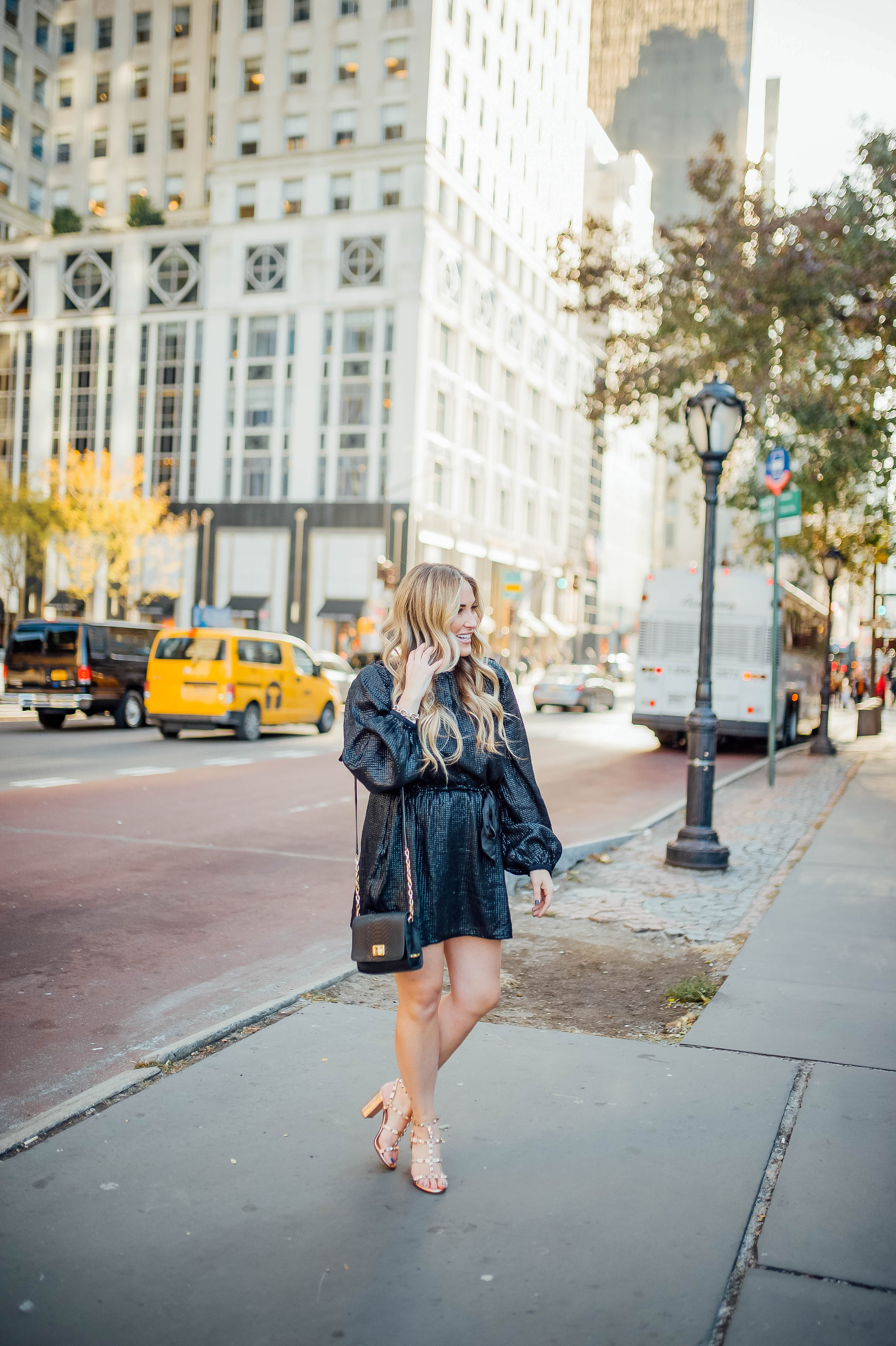 Holiday event style for NYE, Holiday Weddings, Holiday Parties featured by top US fashion blog, Walking in Memphis in High Heels: image of a woman wearing Lana A Boutique puffer jacket, Gigi New York crossbody bag, Valentino Garavani heeled sandals, Kohl’s faux fur leather tech gloves, and a Red Dress Boutique silver dress.