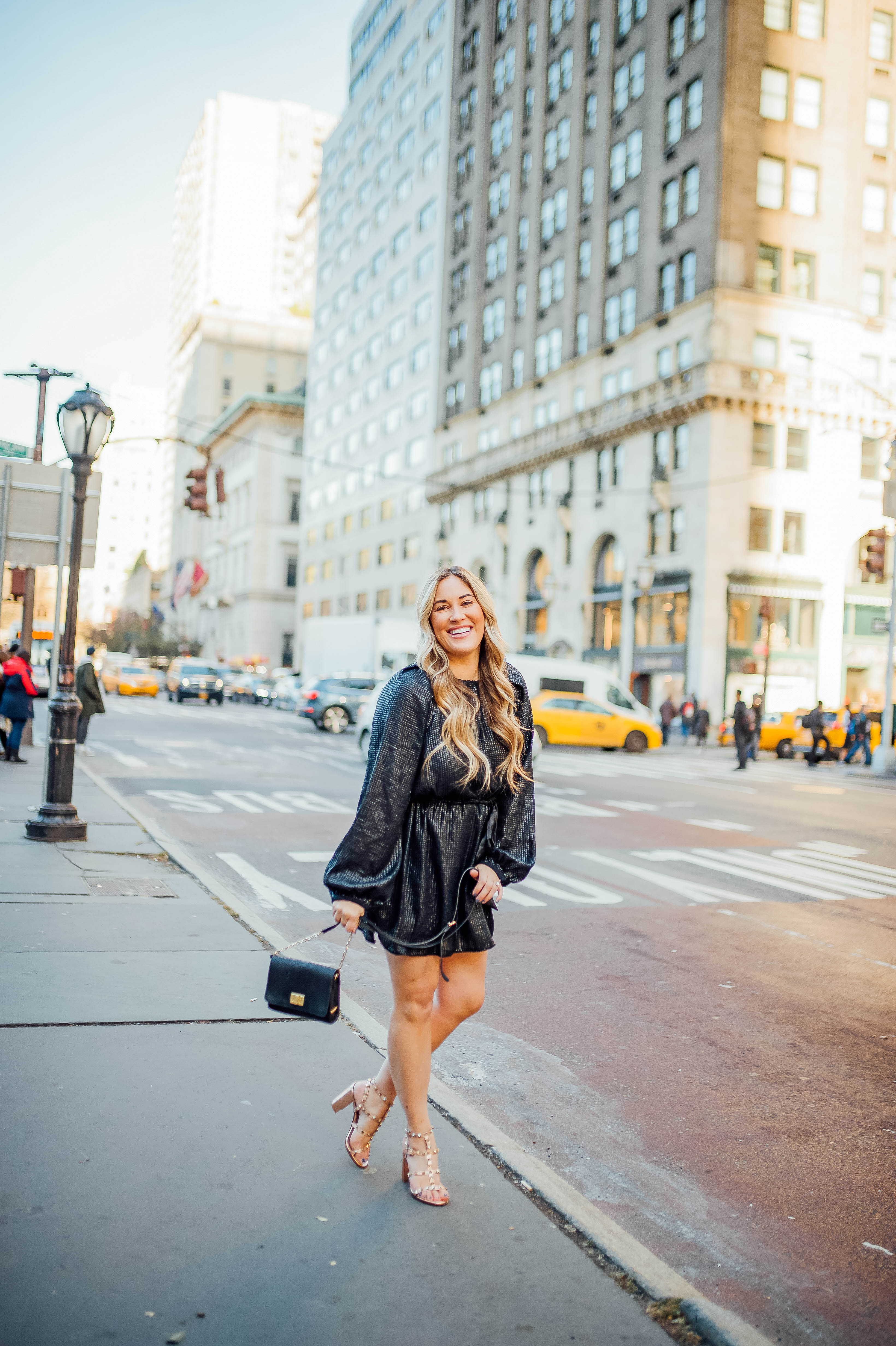 Holiday event style for NYE, Holiday Weddings, Holiday Parties featured by top US fashion blog, Walking in Memphis in High Heels: image of a woman wearing Lana A Boutique puffer jacket, Gigi New York crossbody bag, Valentino Garavani heeled sandals, Kohl’s faux fur leather tech gloves, and a Red Dress Boutique silver dress.