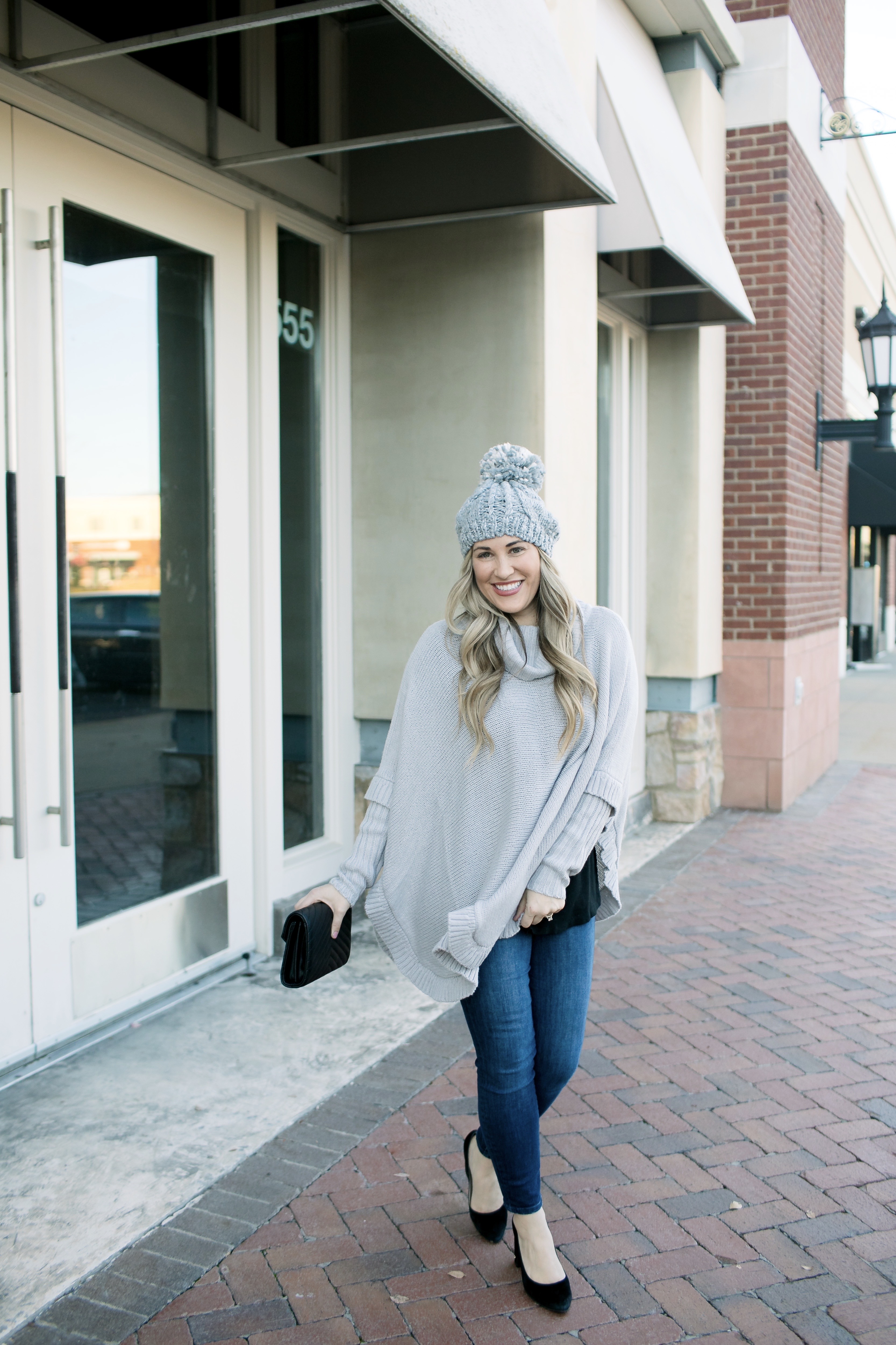 Last Minute Stocking Stuffers from Francesca's at Carriage Crossing featured by top US fashion blog, Walking in Memphis in High Heels: image of a woman wearing Francesca's straight jeans, a quilted clutch, a beanie hat and and a poncho.