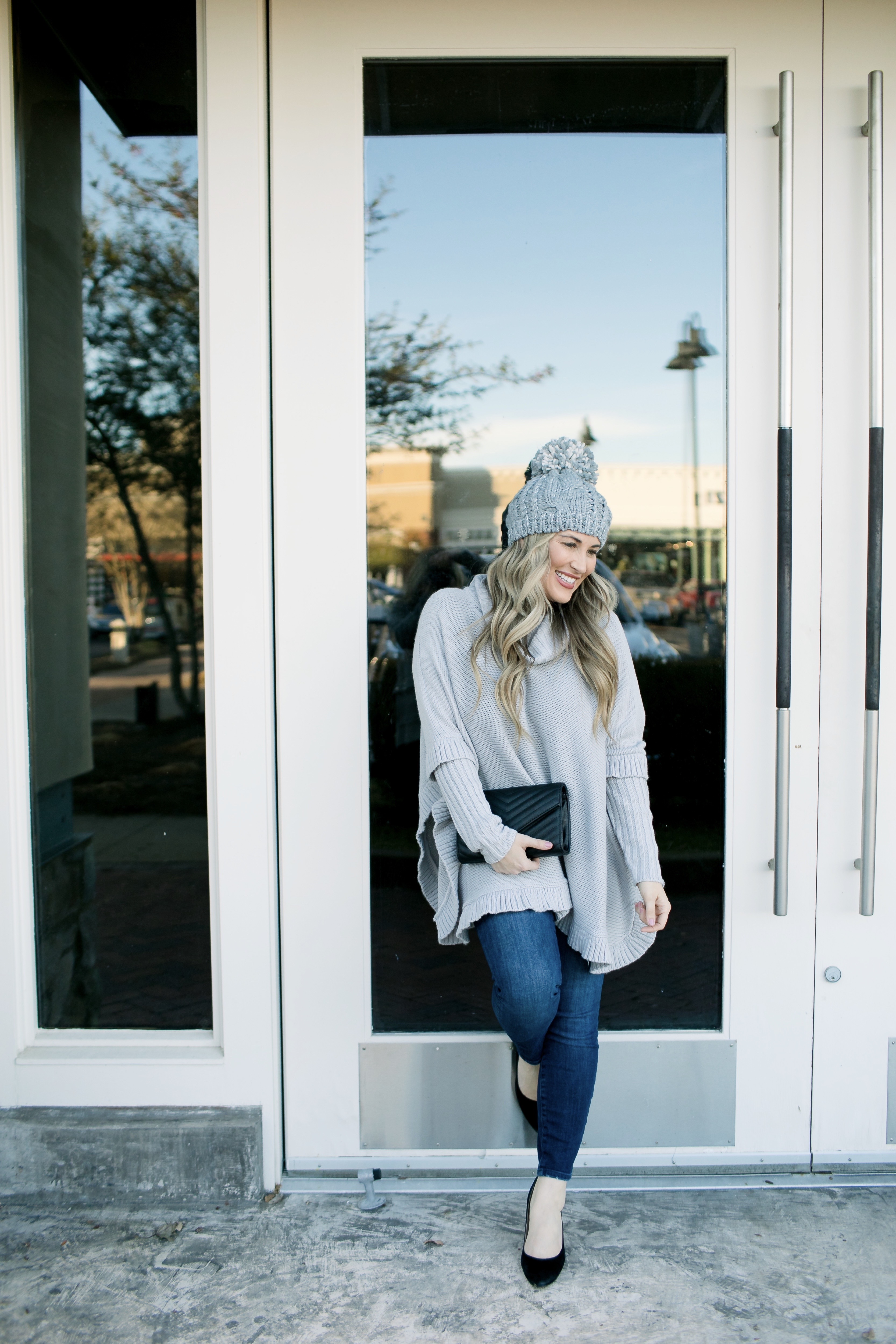 Last Minute Stocking Stuffers from Francesca's at Carriage Crossing featured by top US fashion blog, Walking in Memphis in High Heels: image of a woman wearing Francesca's straight jeans, a quilted clutch, a beanie hat and and a poncho.