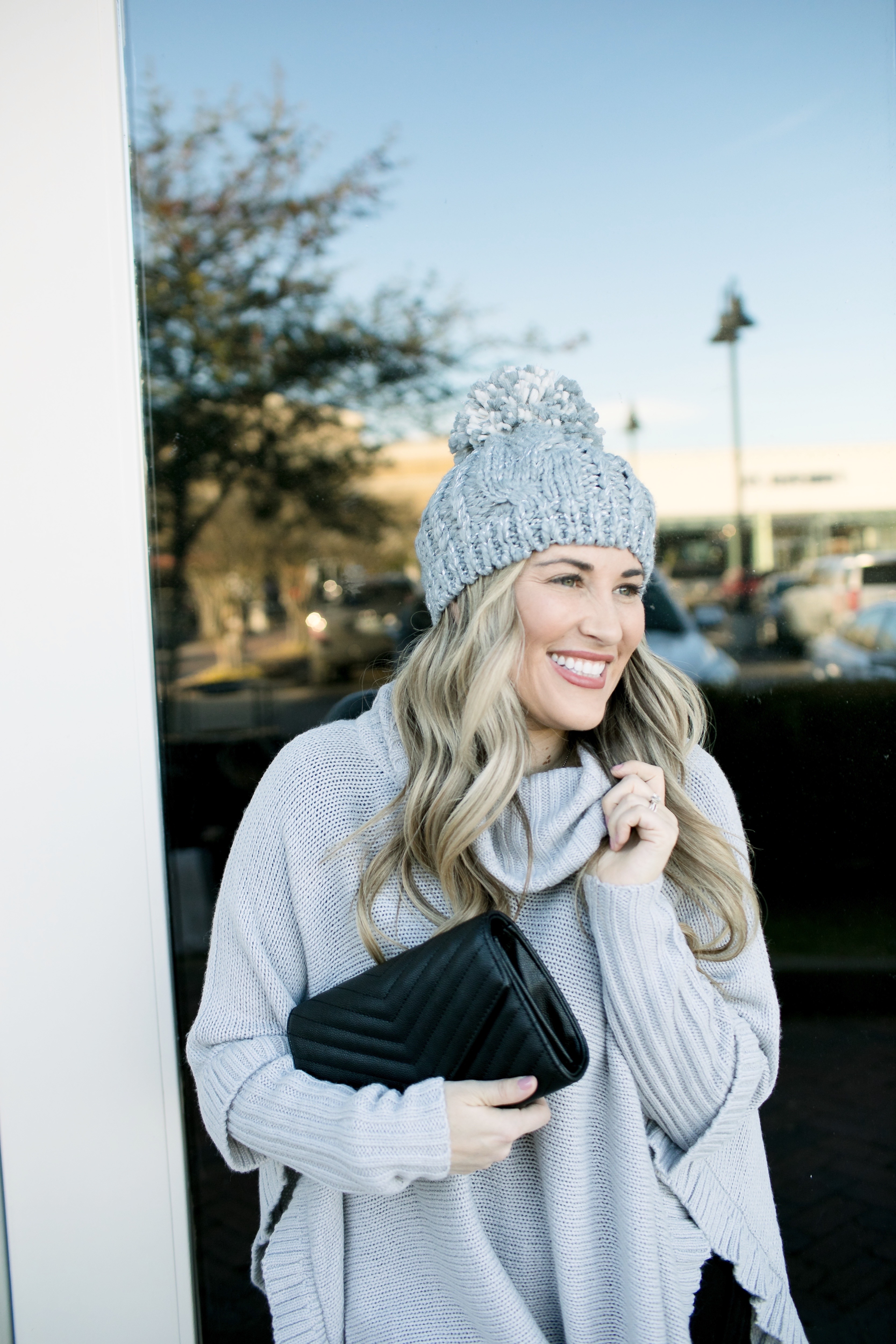 Last Minute Stocking Stuffers from Francesca's at Carriage Crossing featured by top US fashion blog, Walking in Memphis in High Heels: image of a woman wearing Francesca's straight jeans, a quilted clutch, a beanie hat and and a poncho.