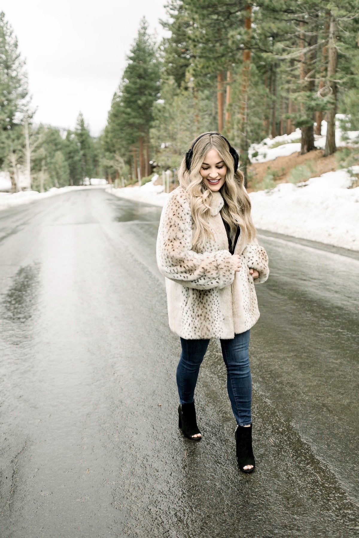 Winter Essentials featured by top Memphis fashion blog, Walking in Memphis in High Heels: image of a woman wearing an ARIAT top, Dennis Basso leopard faux fur coat, Good American high rise skinny jeans, Enzo Angiolini booties, and Surell earmuffs.