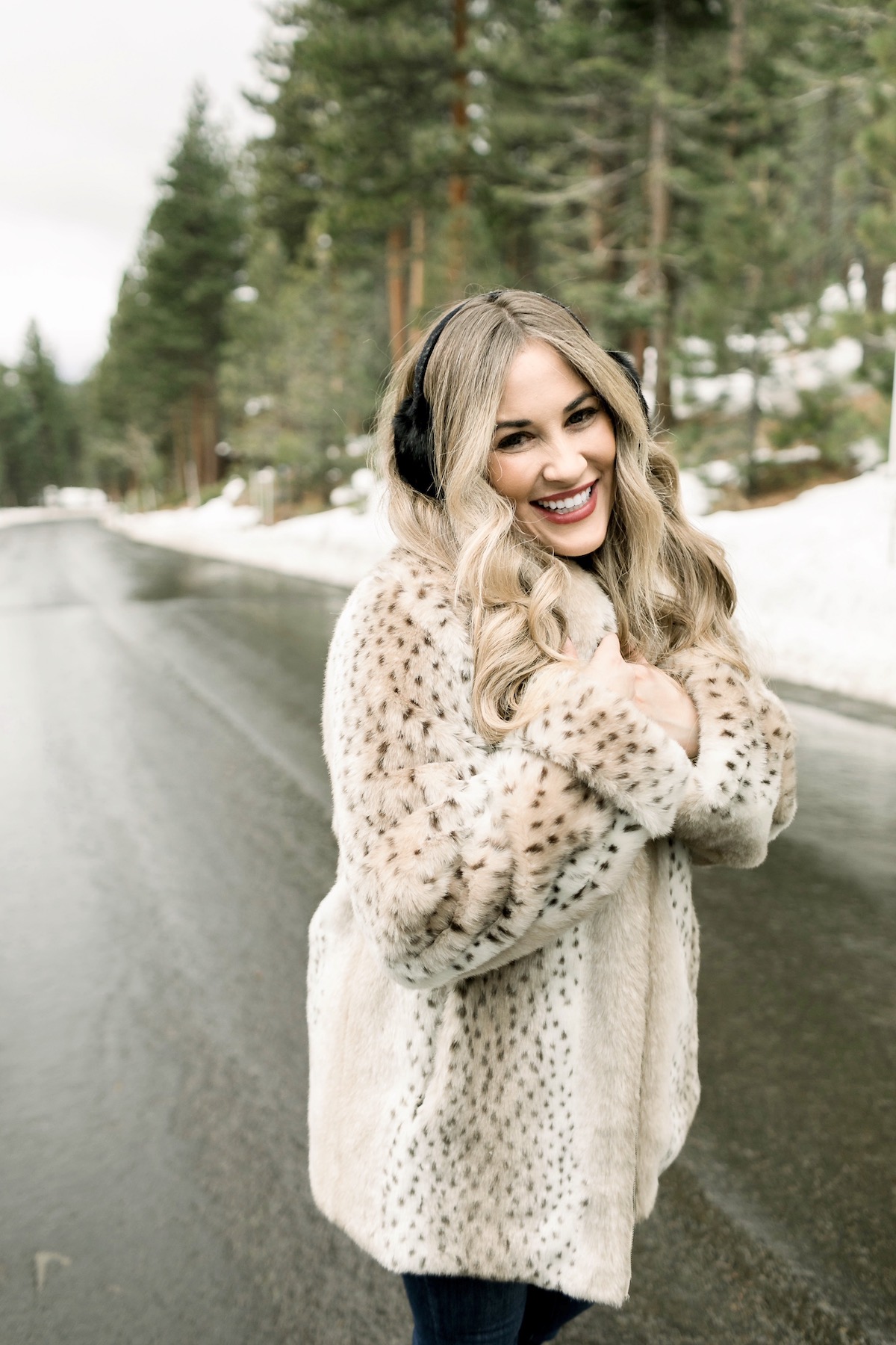 Winter Essentials featured by top Memphis fashion blog, Walking in Memphis in High Heels: image of a woman wearing an ARIAT top, Dennis Basso leopard faux fur coat, Good American high rise skinny jeans, Enzo Angiolini booties, and Surell earmuffs.