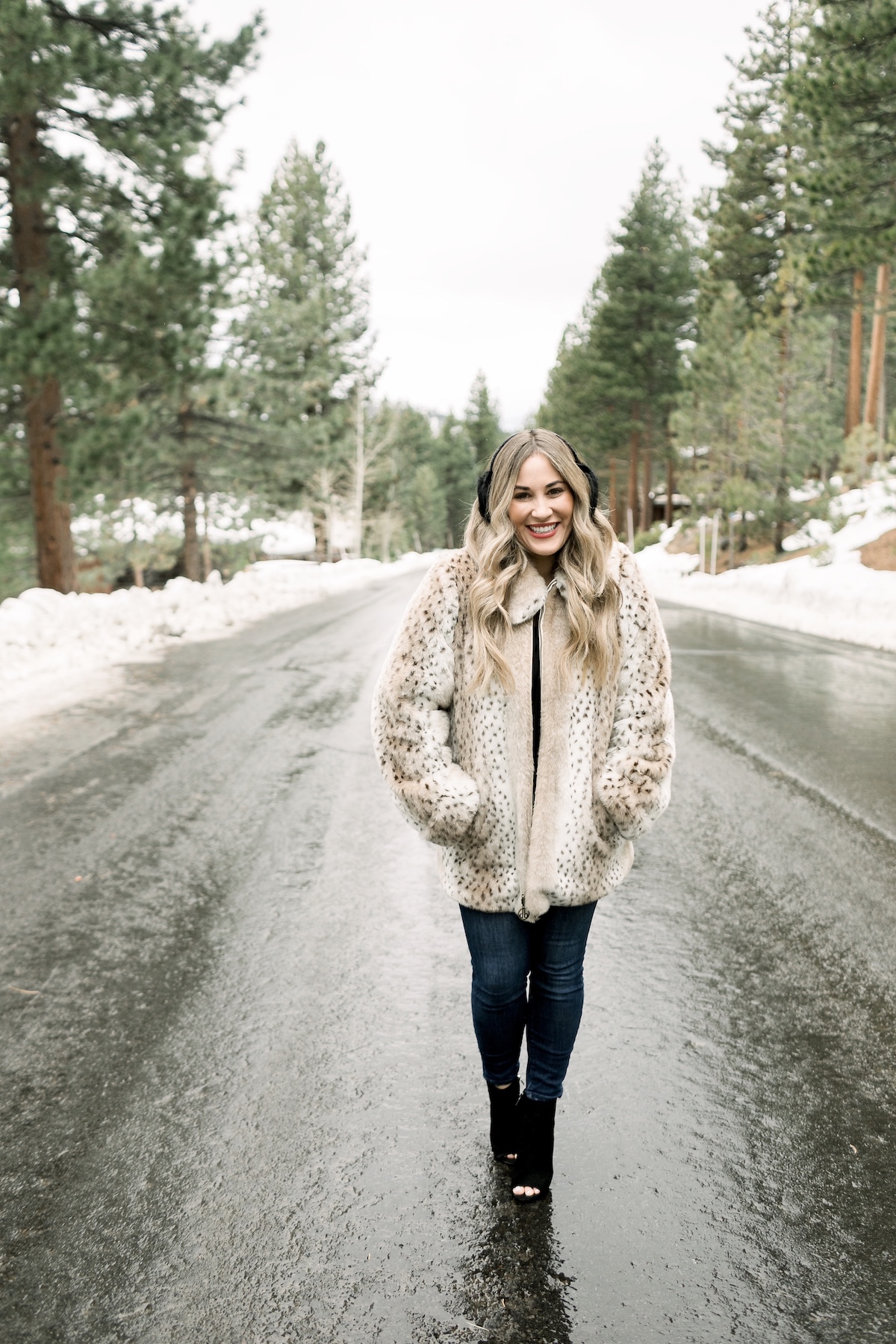 Winter Essentials featured by top Memphis fashion blog, Walking in Memphis in High Heels: image of a woman wearing an ARIAT top, Dennis Basso leopard faux fur coat, Good American high rise skinny jeans, Enzo Angiolini booties, and Surell earmuffs.