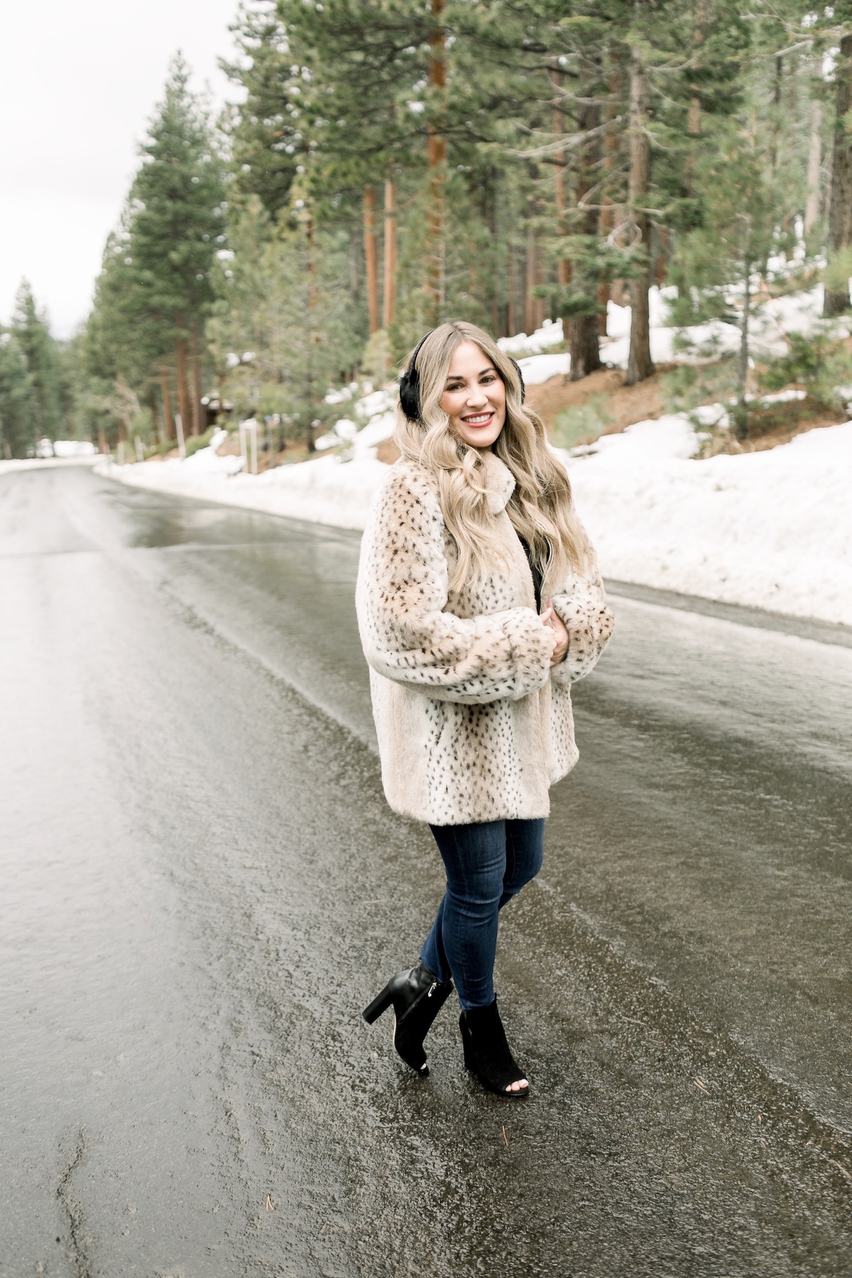 Winter Essentials featured by top Memphis fashion blog, Walking in Memphis in High Heels: image of a woman wearing an ARIAT top, Dennis Basso leopard faux fur coat, Good American high rise skinny jeans, Enzo Angiolini booties, and Surell earmuffs.