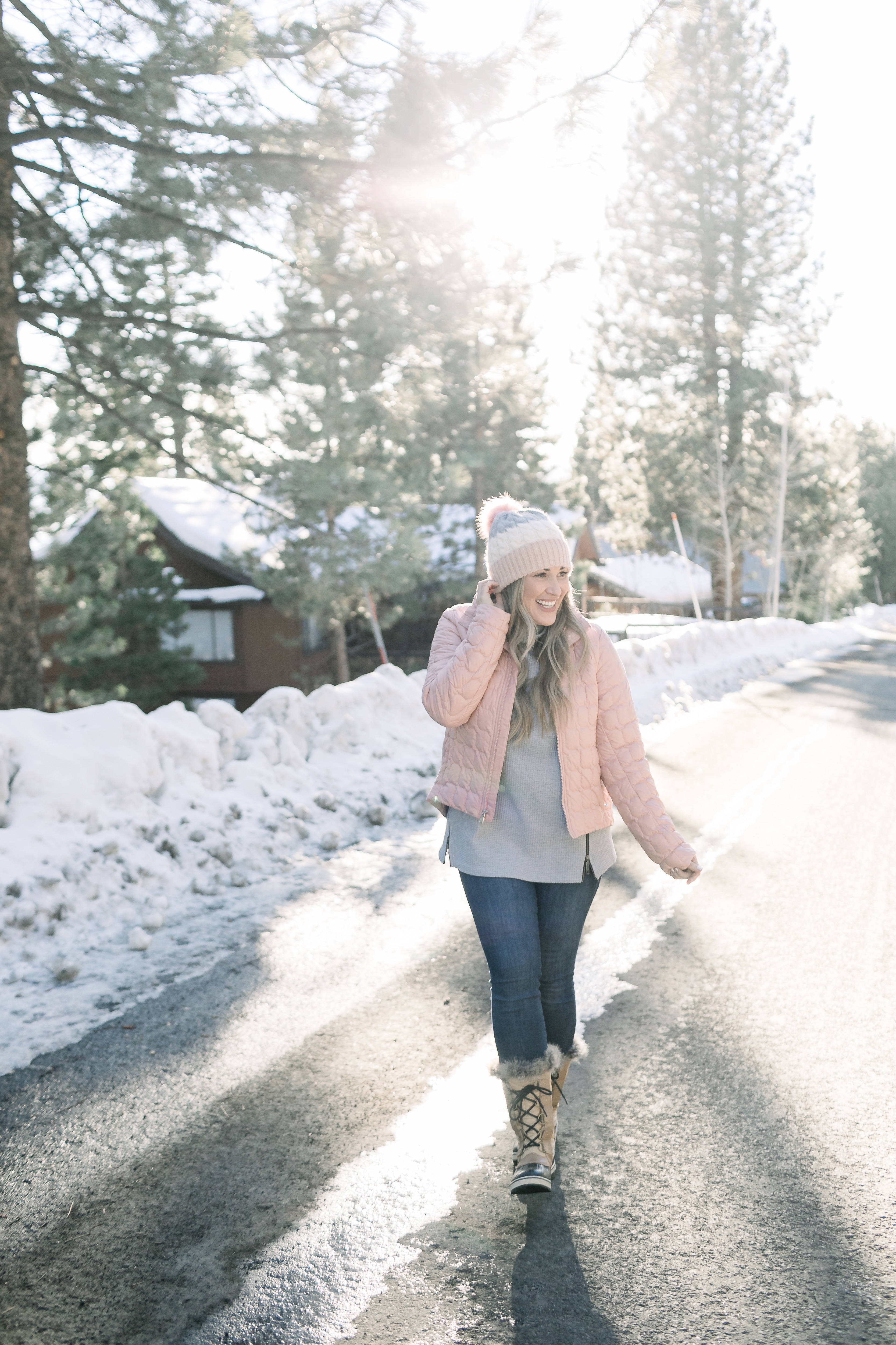 How to Wear Pastels in the Winter, fashion tips featured by top Memphis blog, Walking in Memphis in High Heels: image of a woman wearing a light pink The North Face crop jacket, ASOS blush pom beanie, Sorel blush snow boots.